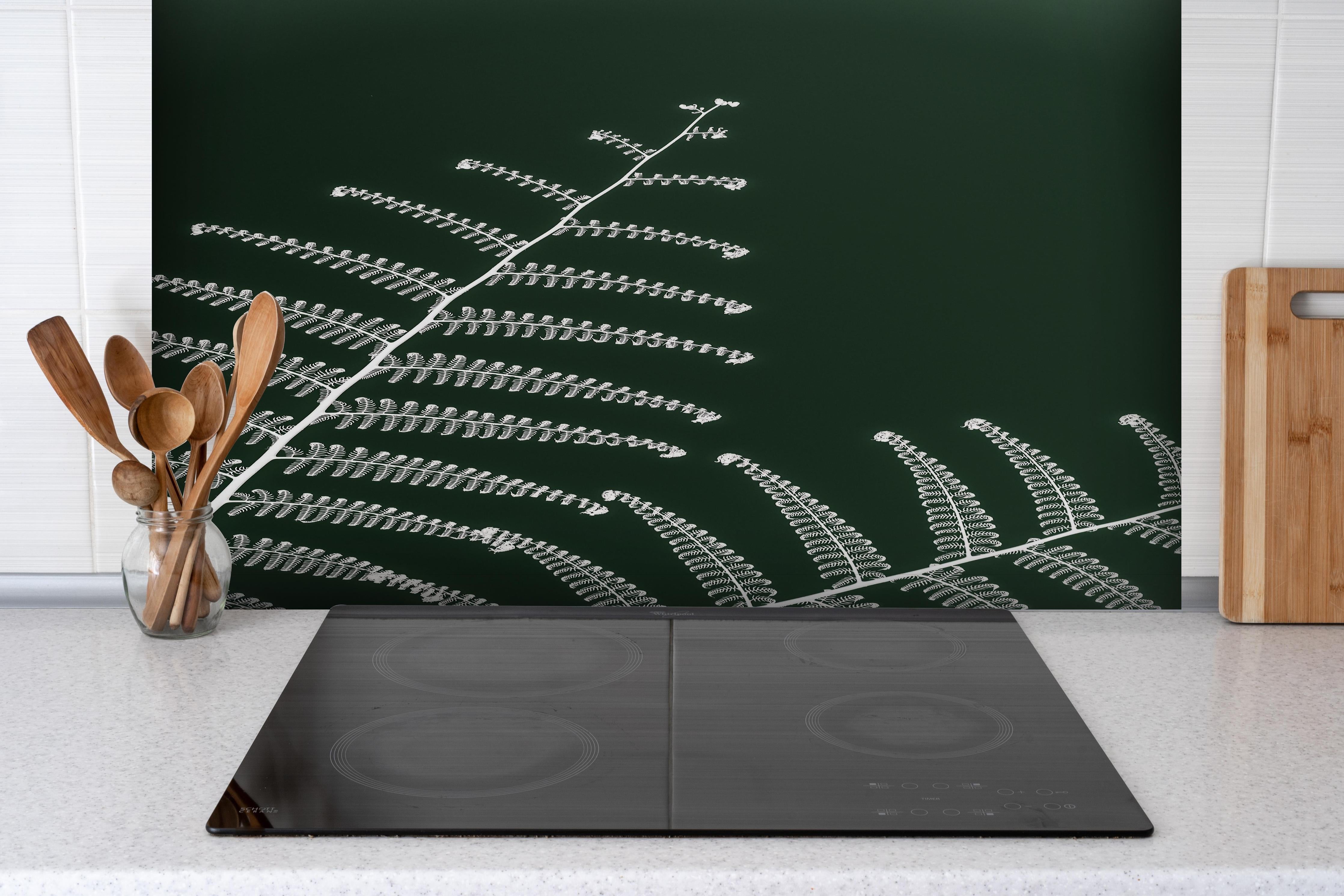 Spritzschutz - Detailreiches, grünes Wald-Farn-Motiv hinter einem Cerankochfeld zwischen Holz-Kochutensilien