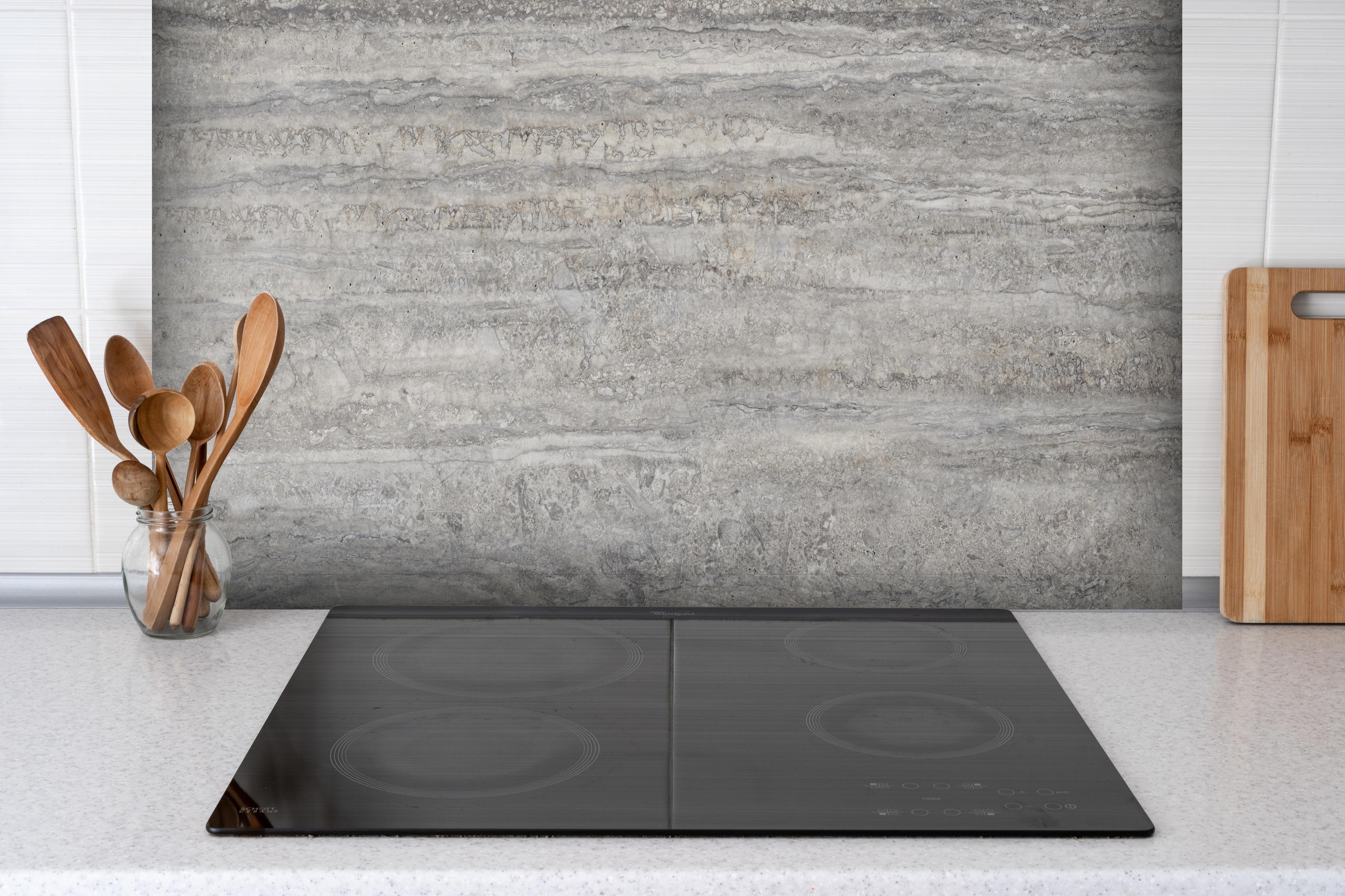 Spritzschutz - Dezenter Travertin Marmor hinter einem Cerankochfeld zwischen Holz-Kochutensilien