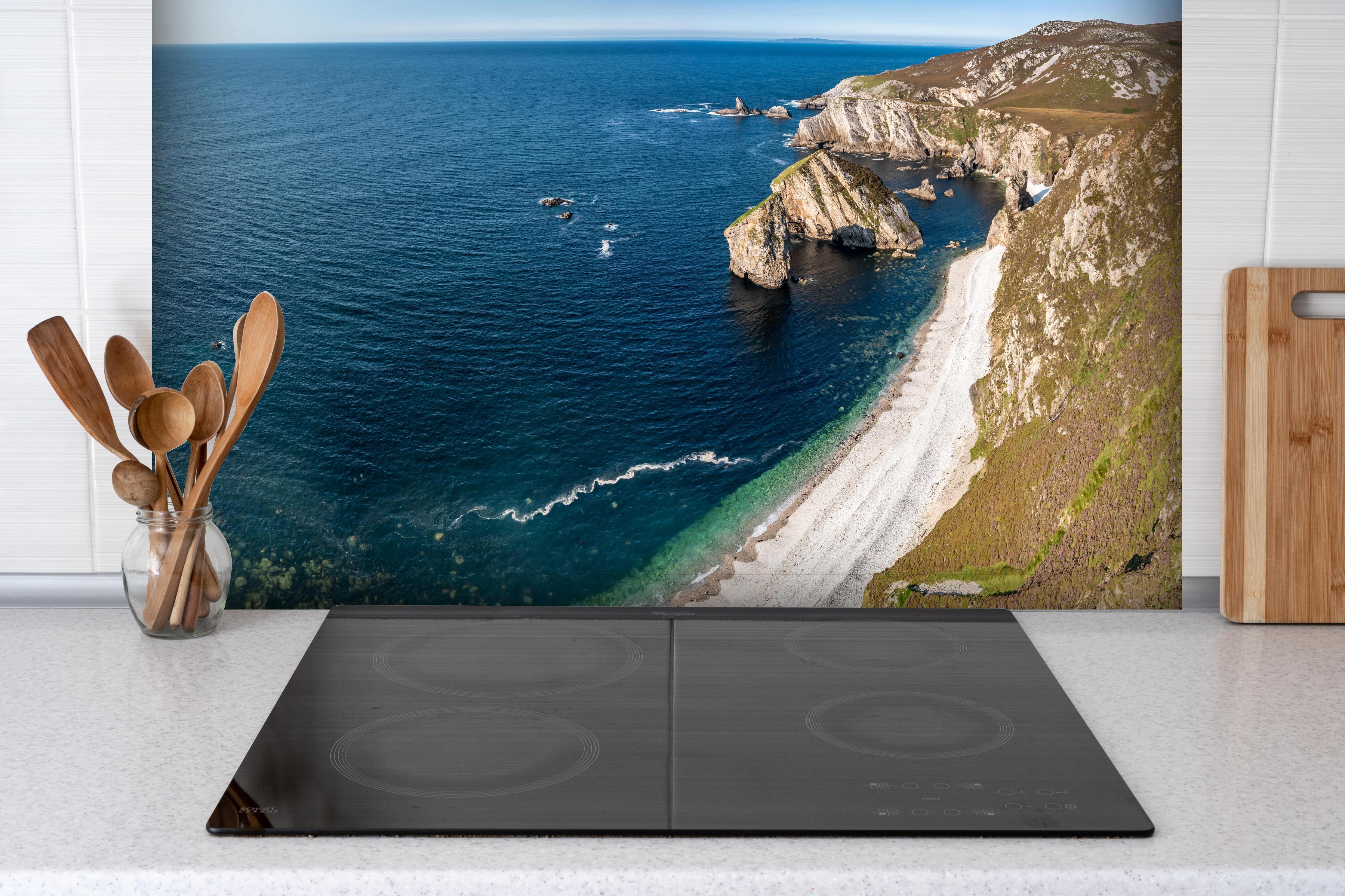 Spritzschutz - Die Bucht Glenlough hinter einem Cerankochfeld zwischen Holz-Kochutensilien