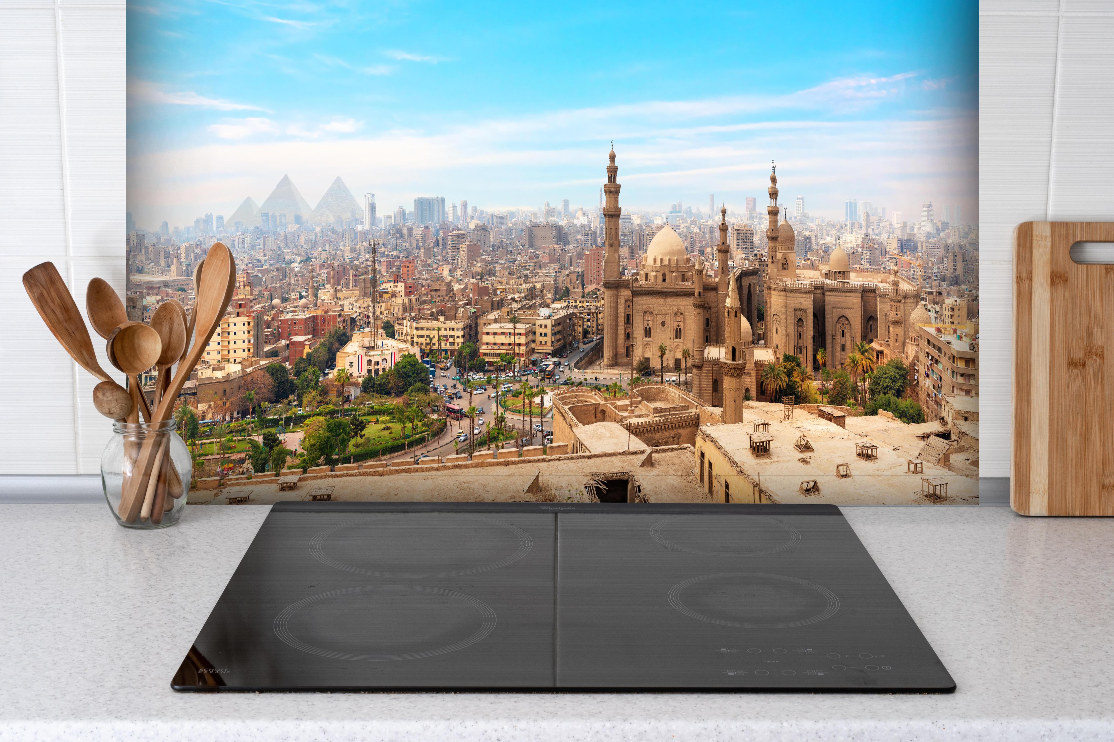 Spritzschutz - Die Moschee-Madrassa von Sultan Hassan im Panorama von Kairo hinter einem Cerankochfeld zwischen Holz-Kochutensilien