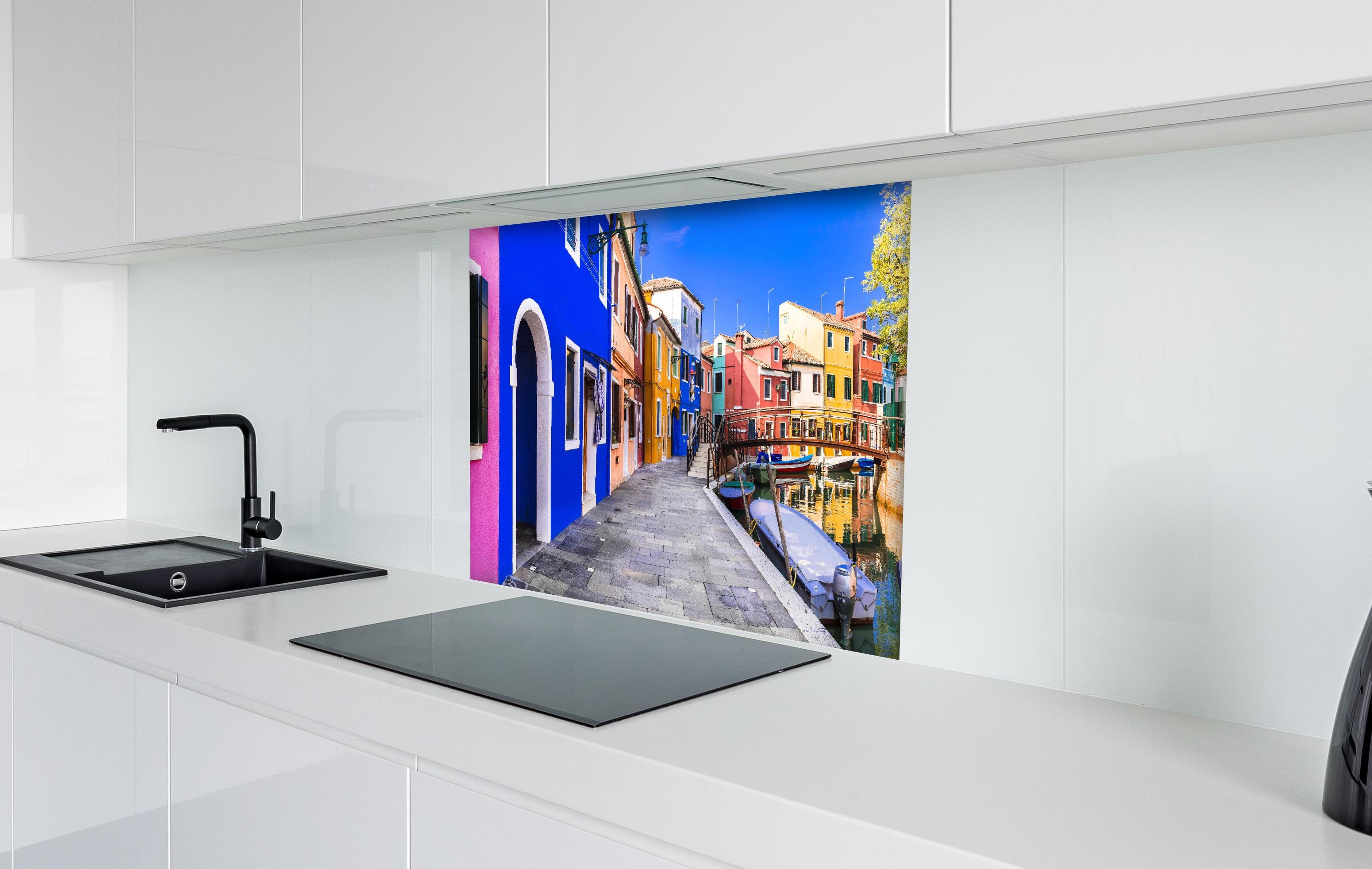 Spritzschutz - Die farbenfrohe Insel Burano hinter einem Cerankochfeld zwischen Holz-Kochutensilien