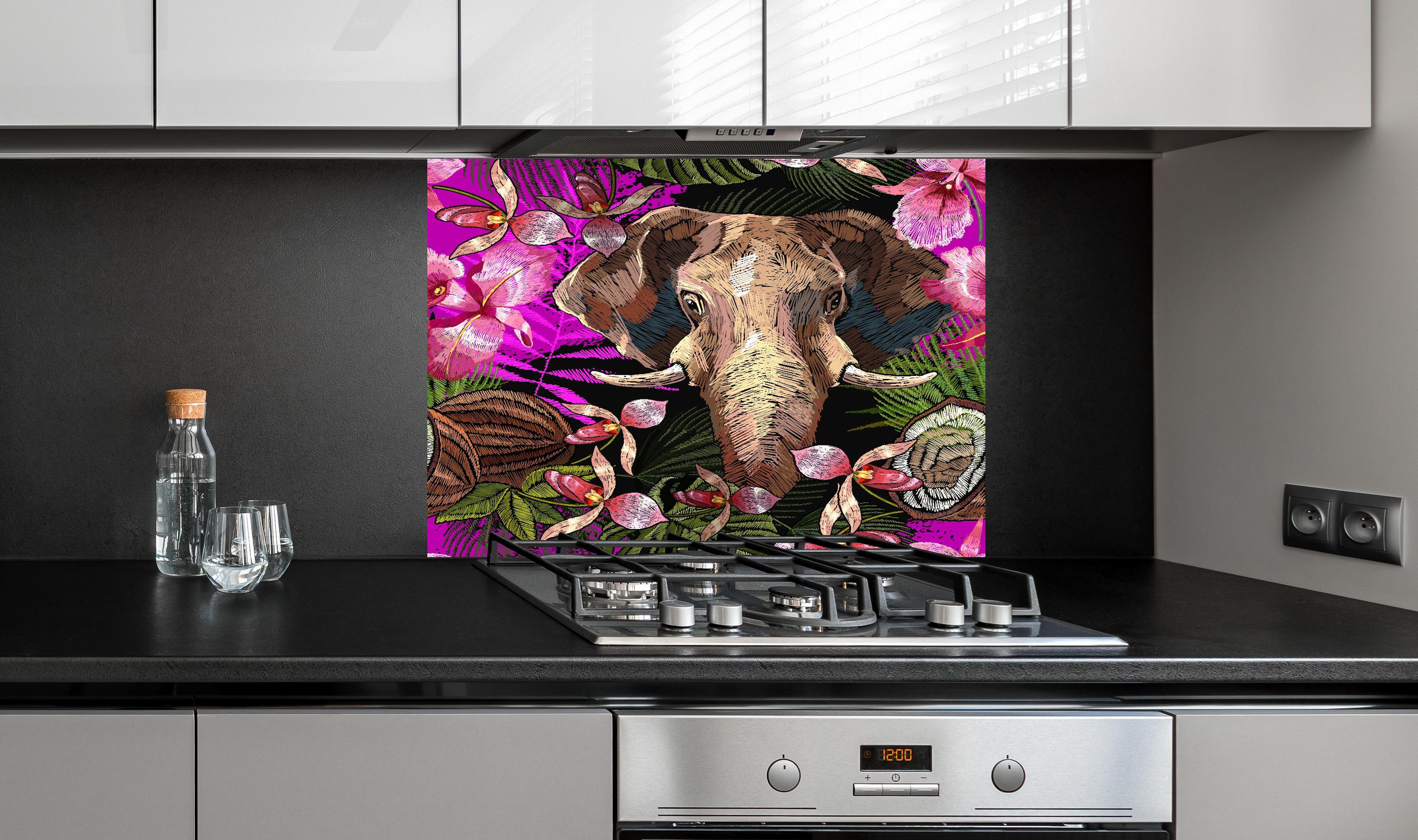 Spritzschutz - Dschungelnacht Elefant und tropische Blumen hinter einem Cerankochfeld zwischen Holz-Kochutensilien