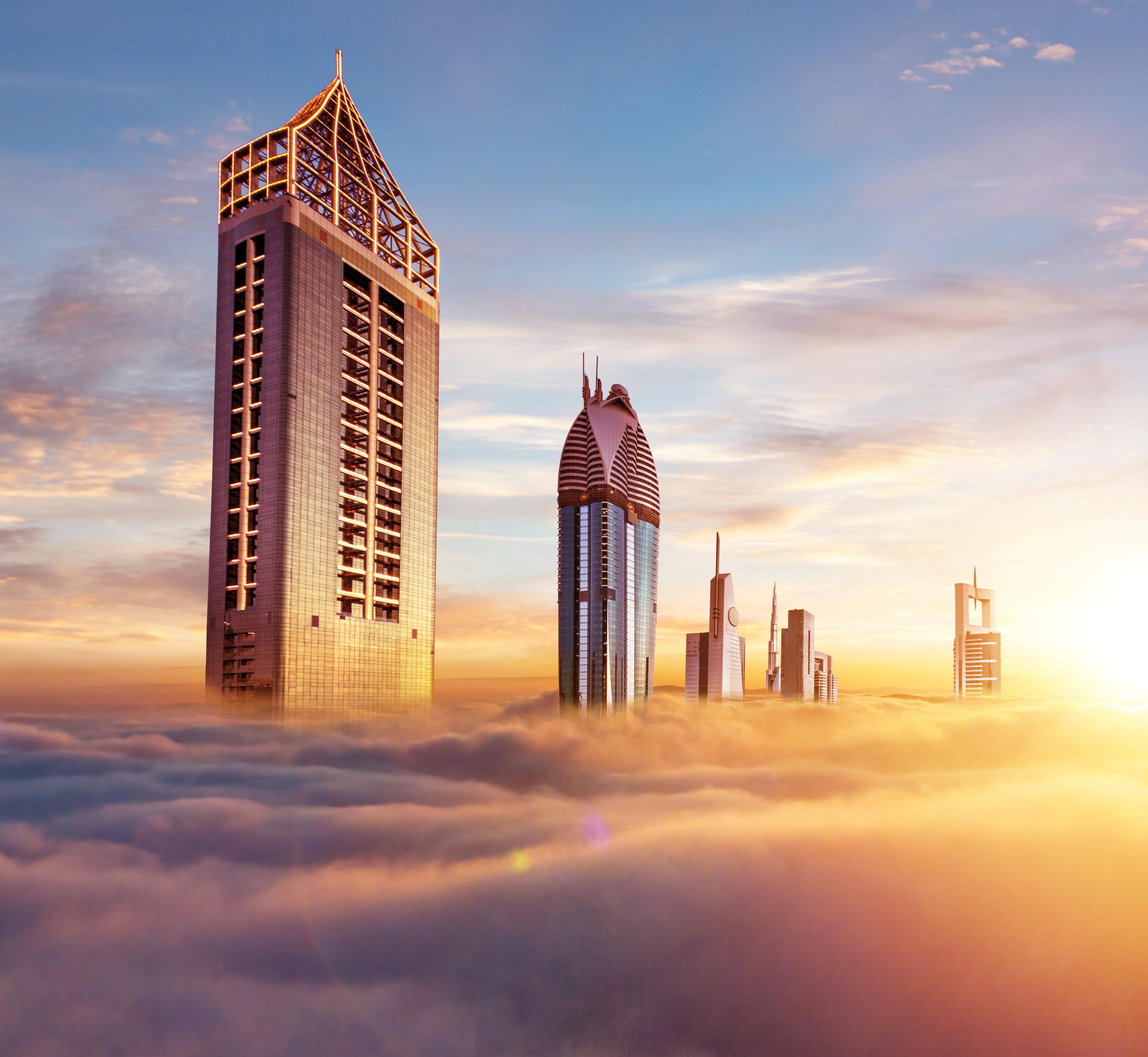Spritzschutz-Dubai Wolkenkratzer über den Wolken bei Sonnenaufgang
