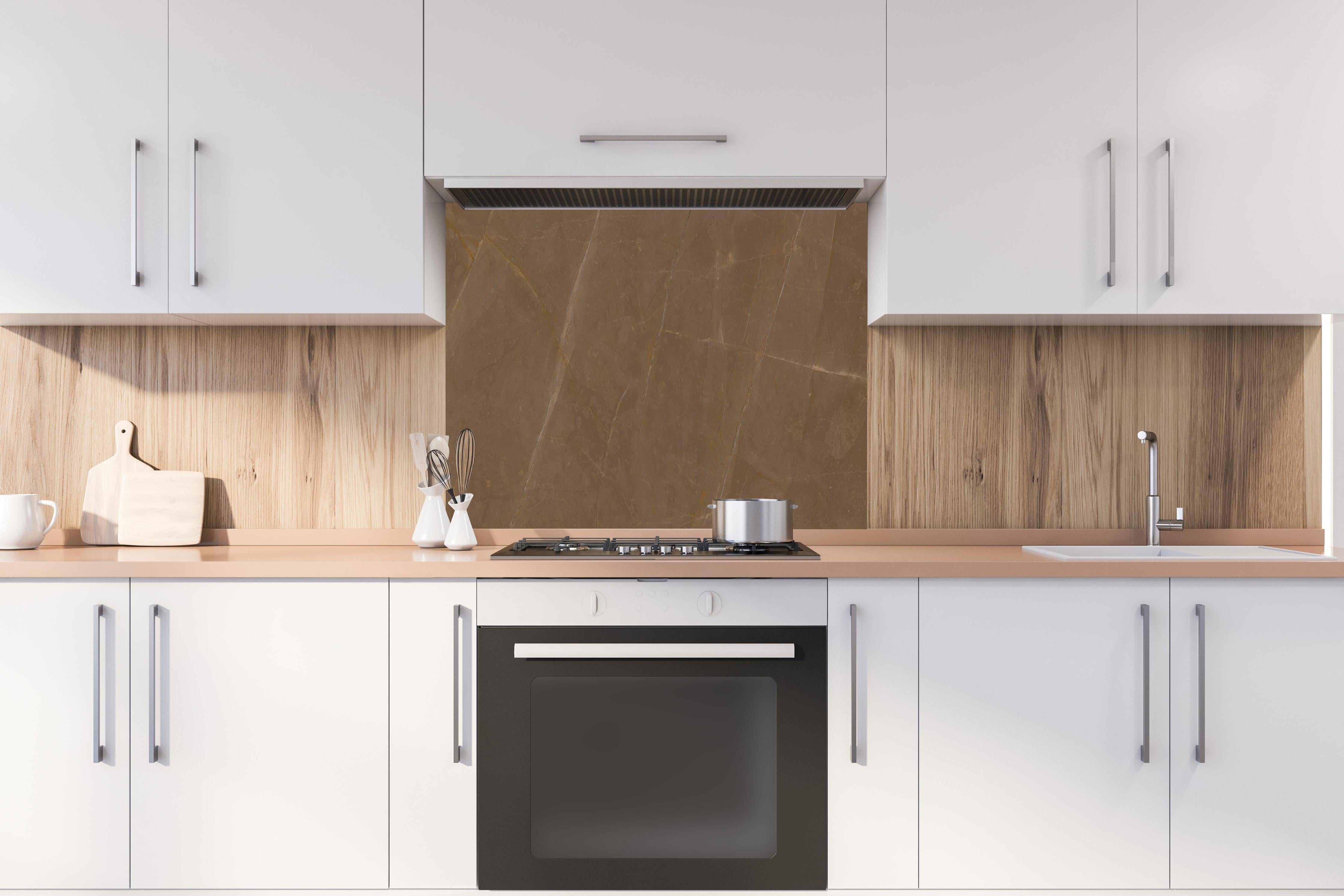 Spritzschutz - Dunkelbrauner Marmor hinter einem Cerankochfeld zwischen Holz-Kochutensilien