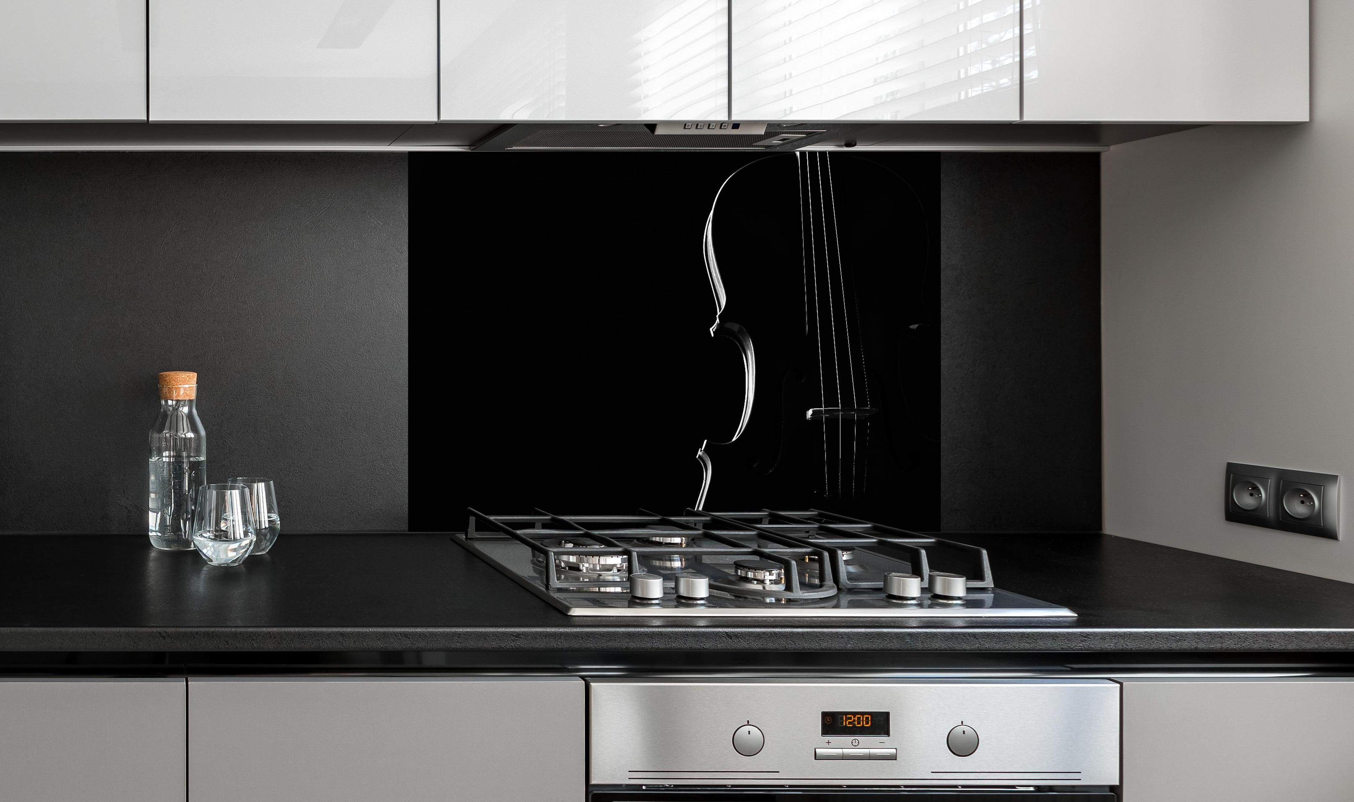 Spritzschutz - Dunkles Bild einer Violine hinter einem Cerankochfeld zwischen Holz-Kochutensilien