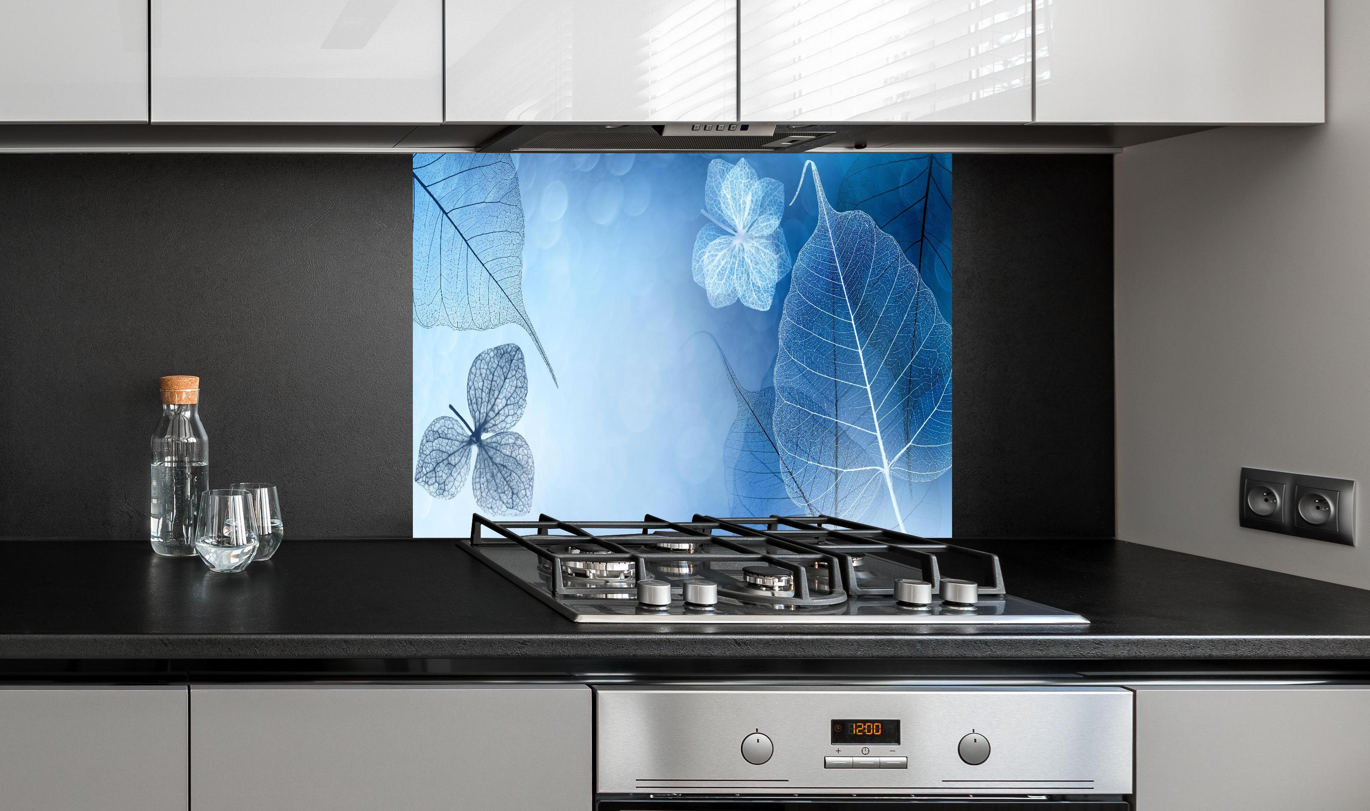 Spritzschutz - Durchscheinende Blattstrukturen in Makroaufnahme hinter einem Cerankochfeld zwischen Holz-Kochutensilien