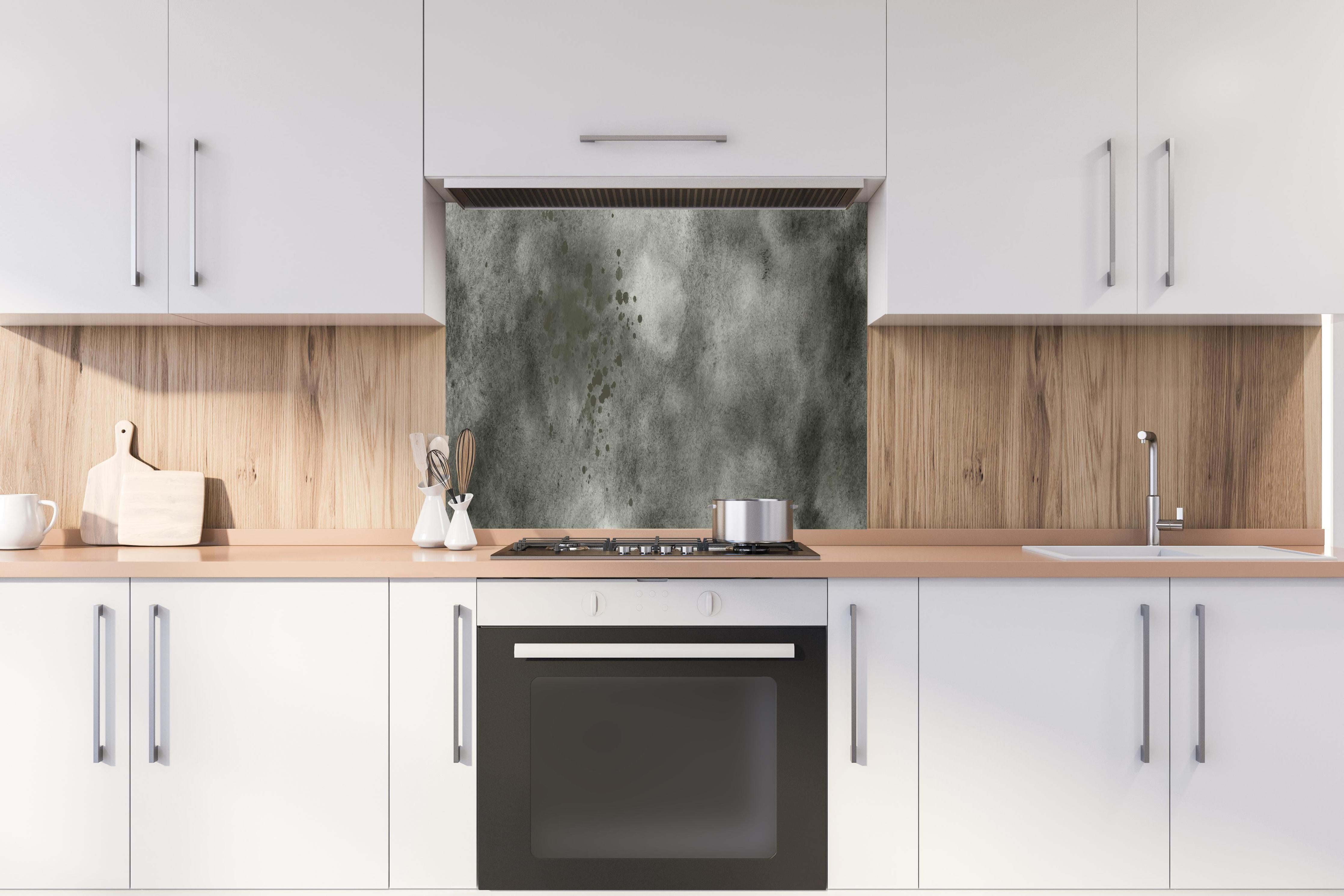 Spritzschutz - Dynamische Aquarelltextur in Grau und Schwarz hinter einem Cerankochfeld zwischen Holz-Kochutensilien