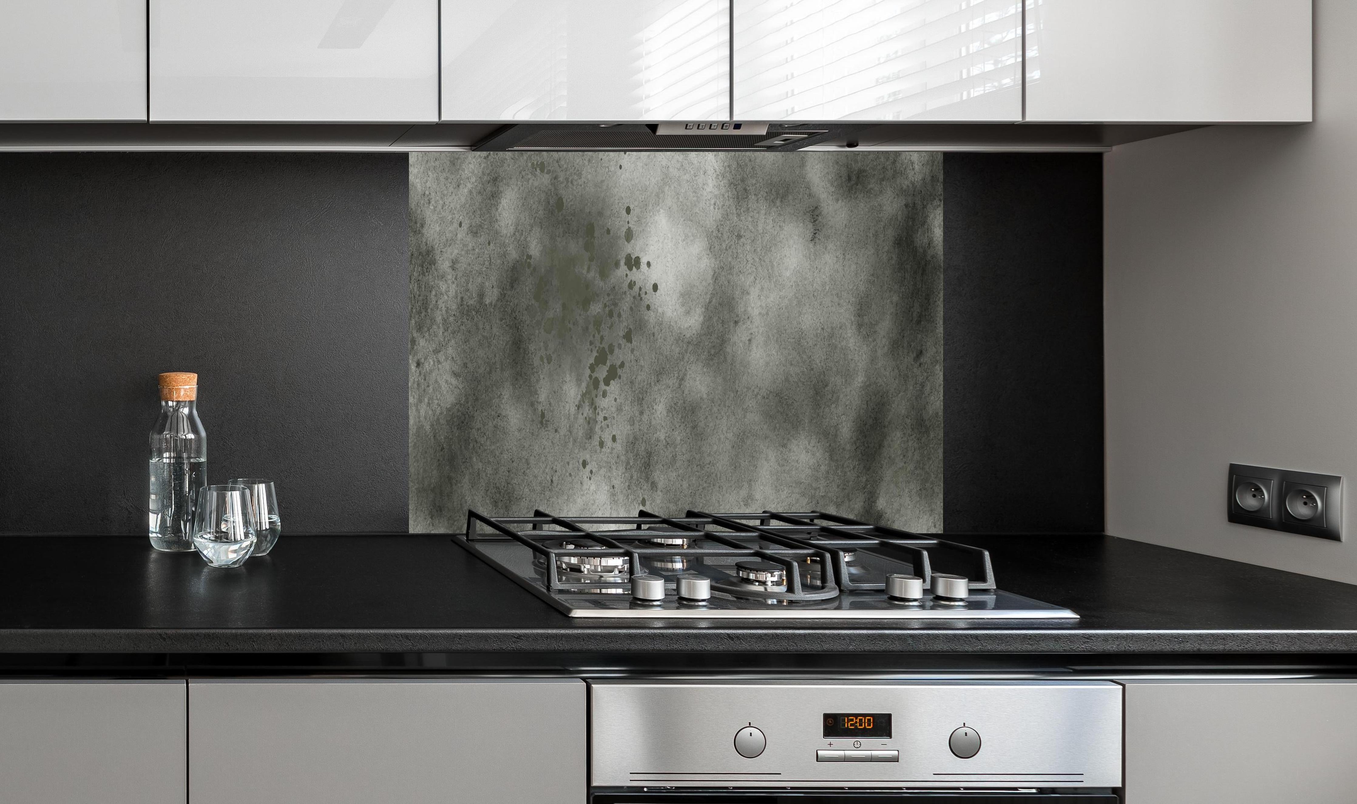 Spritzschutz - Dynamische Aquarelltextur in Grau und Schwarz hinter einem Cerankochfeld zwischen Holz-Kochutensilien
