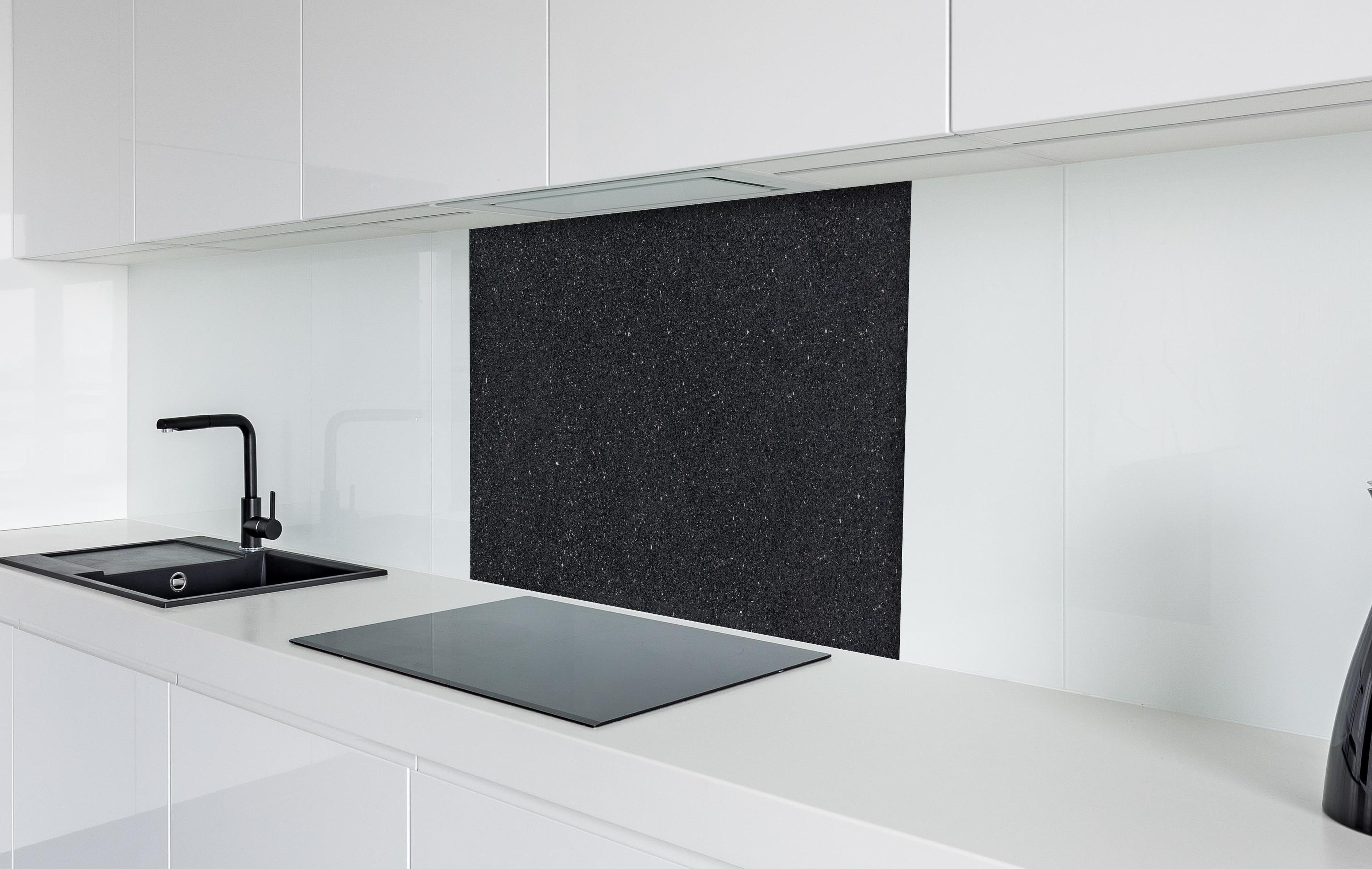 Spritzschutz - Edle schwarze Granite Marmor-Textur hinter einem Cerankochfeld zwischen Holz-Kochutensilien