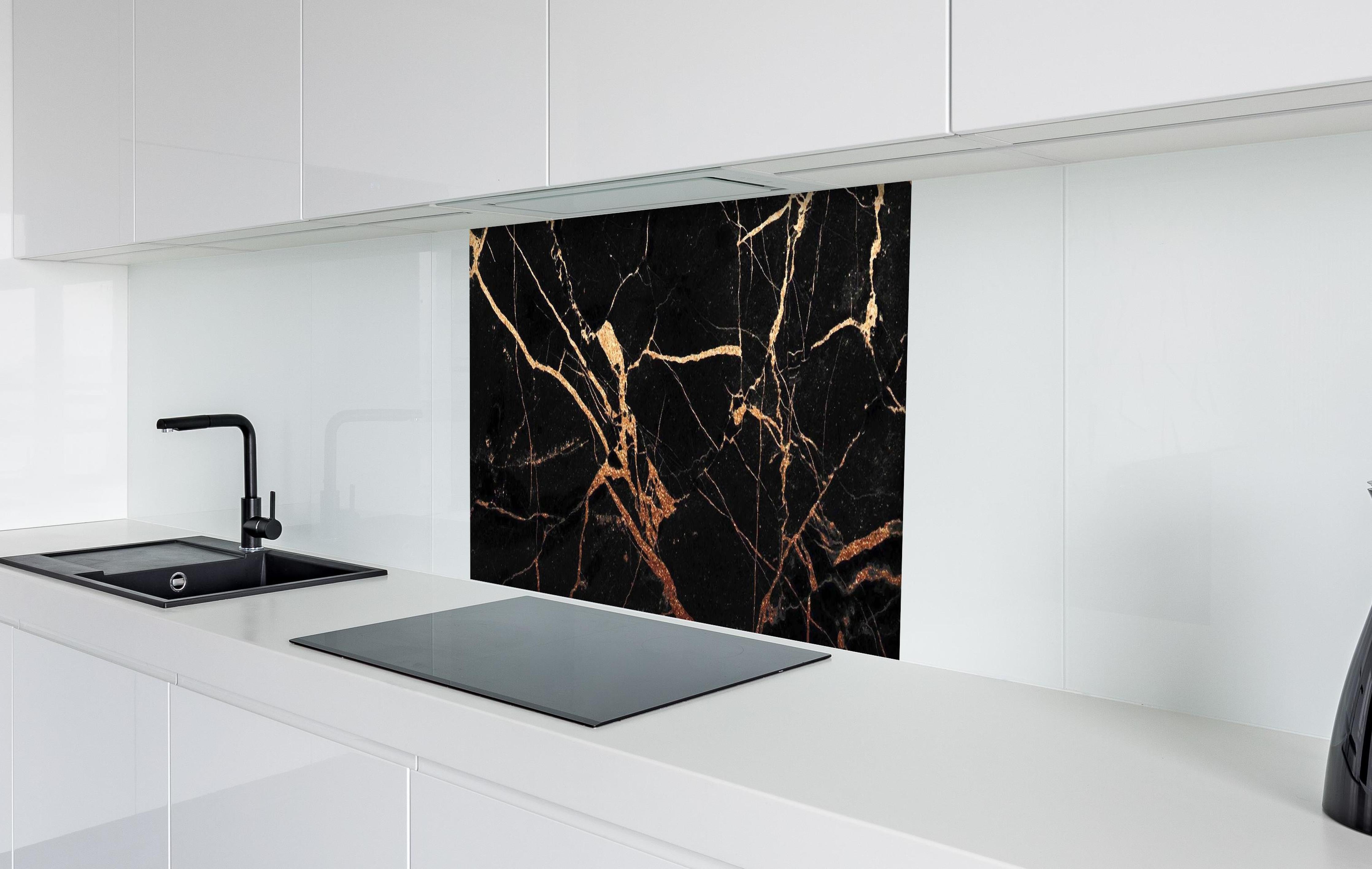 Spritzschutz - Edler Schwarz-Gold Marmor-Optik hinter einem Cerankochfeld zwischen Holz-Kochutensilien