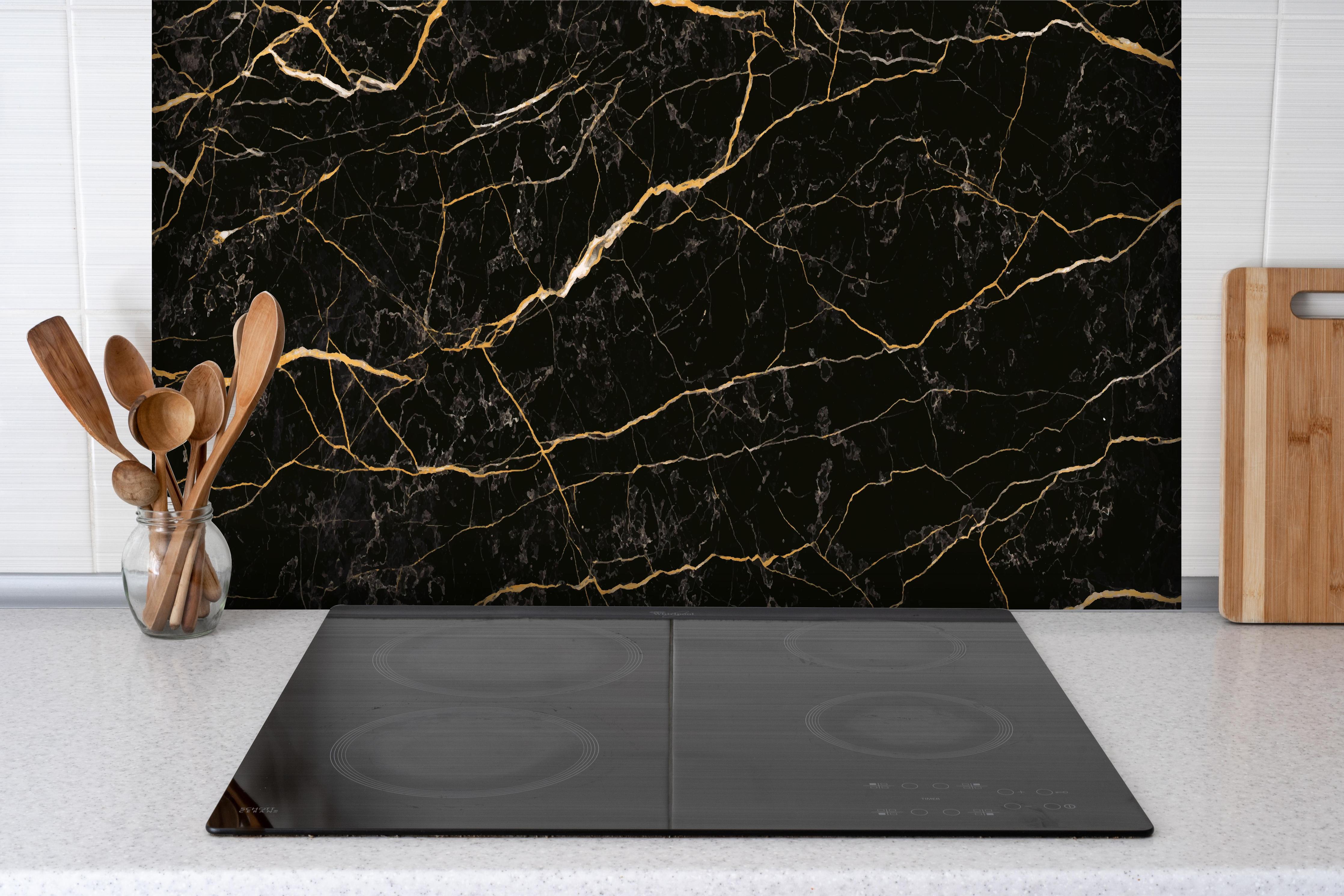 Spritzschutz - Edler Schwarzer Marmor mit Goldadern hinter einem Cerankochfeld zwischen Holz-Kochutensilien