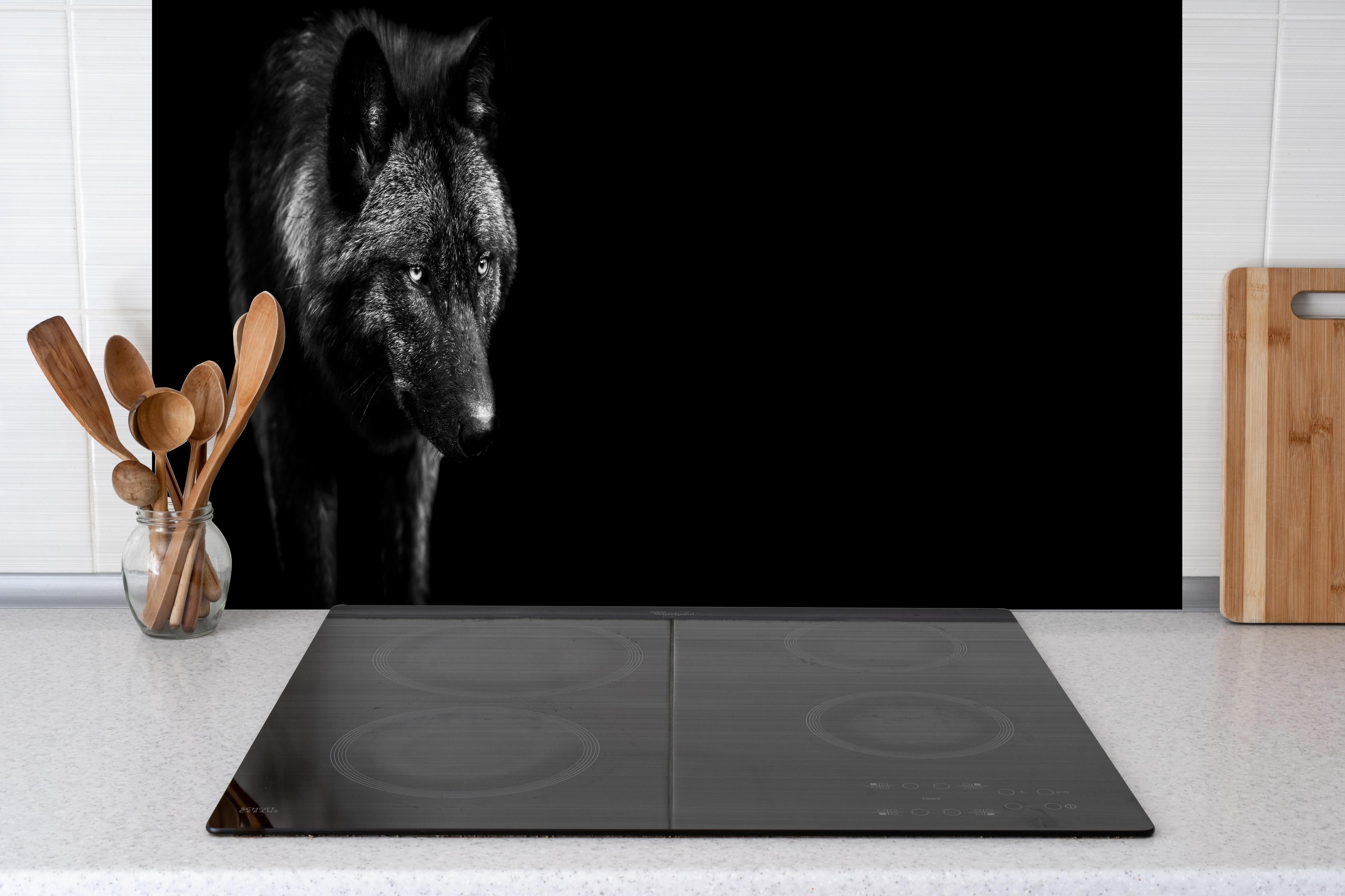 Spritzschutz - Eindrucksvolles Schwarz-Weiß Wolf-Profil hinter einem Cerankochfeld zwischen Holz-Kochutensilien