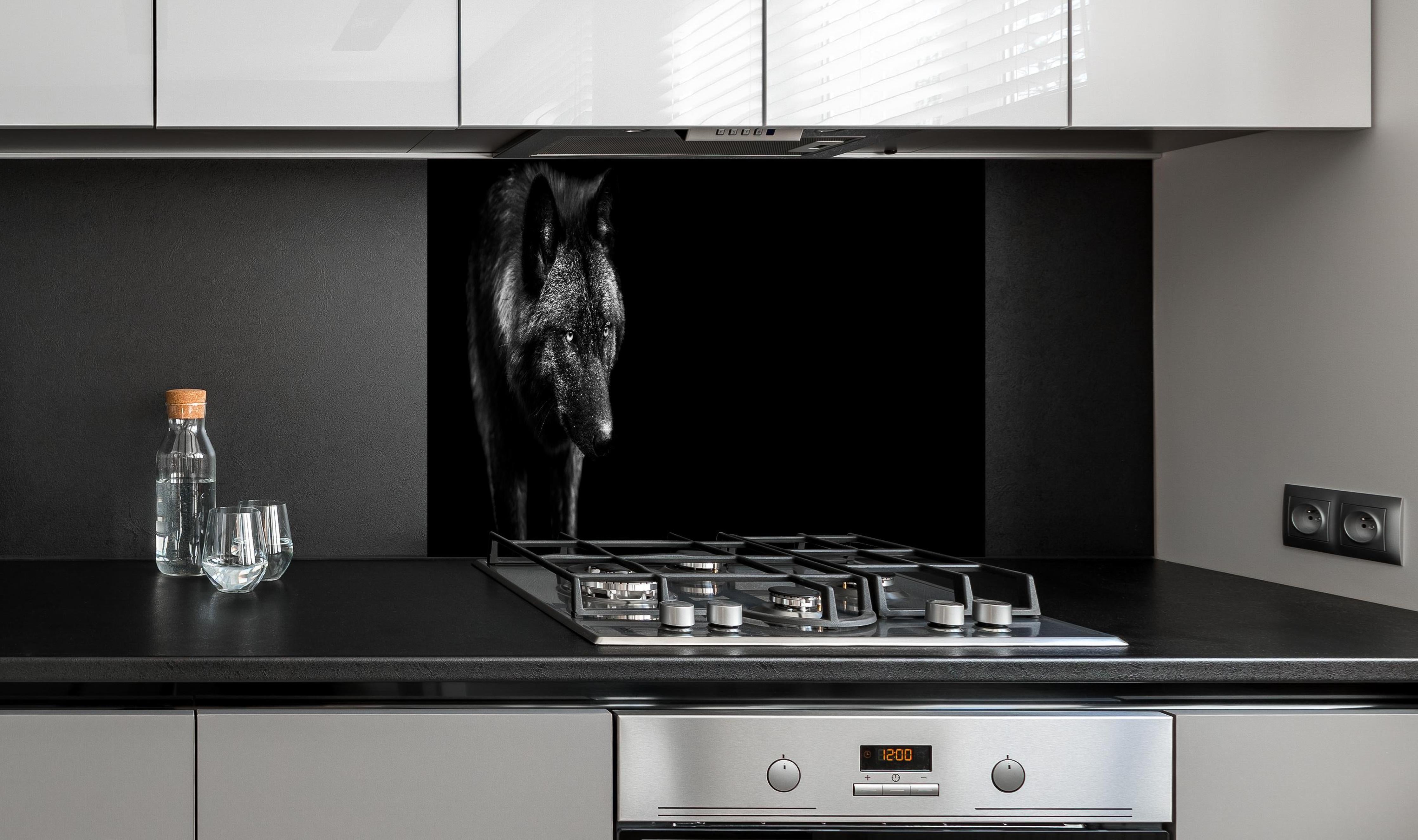Spritzschutz - Eindrucksvolles Schwarz-Weiß Wolf-Profil hinter einem Cerankochfeld zwischen Holz-Kochutensilien