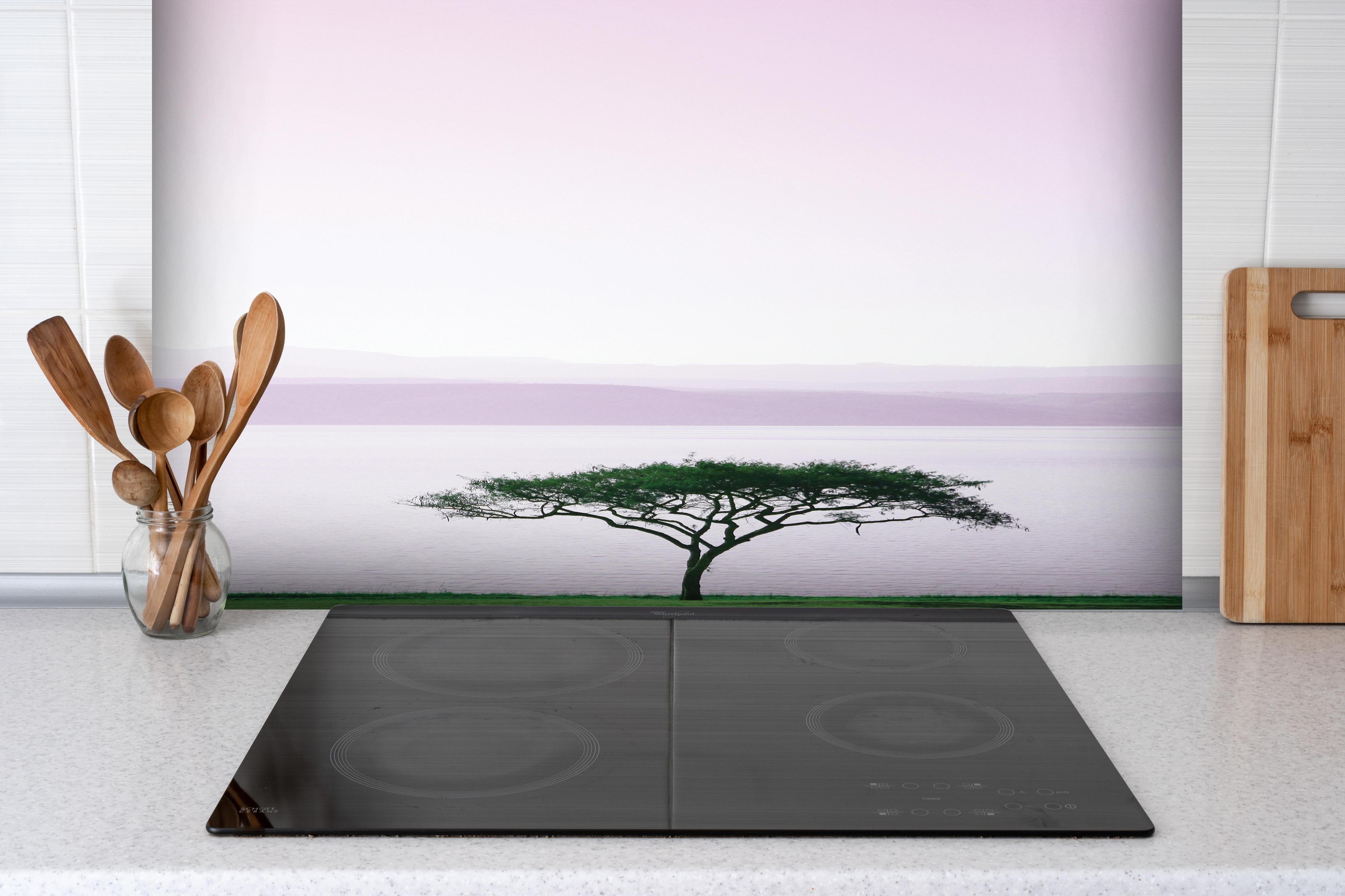 Spritzschutz - Einsamer Baum bei Morgengrauen am Meer hinter einem Cerankochfeld zwischen Holz-Kochutensilien