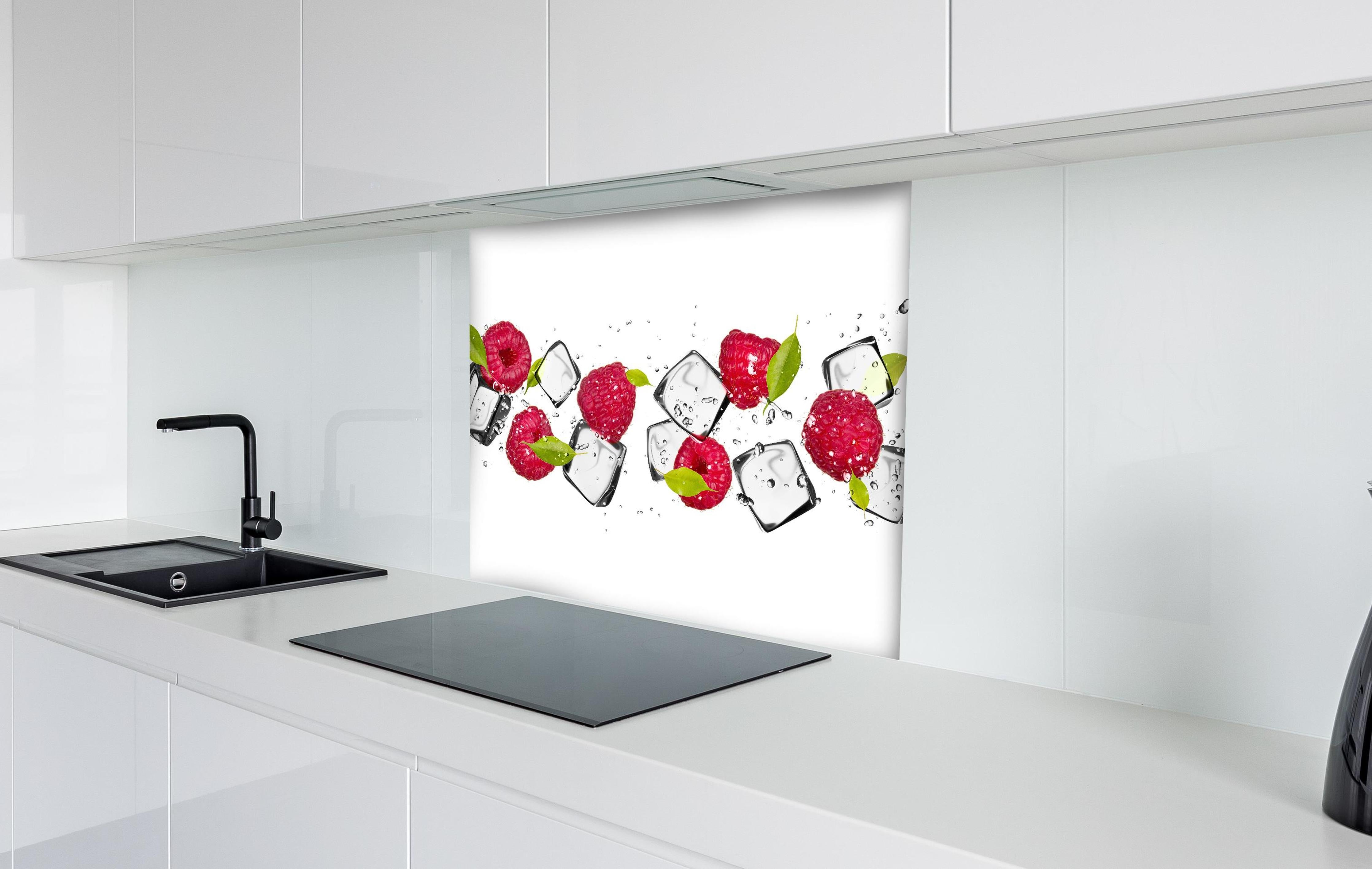 Spritzschutz - Eiswürfel mit Himbeeren hinter einem Cerankochfeld zwischen Holz-Kochutensilien