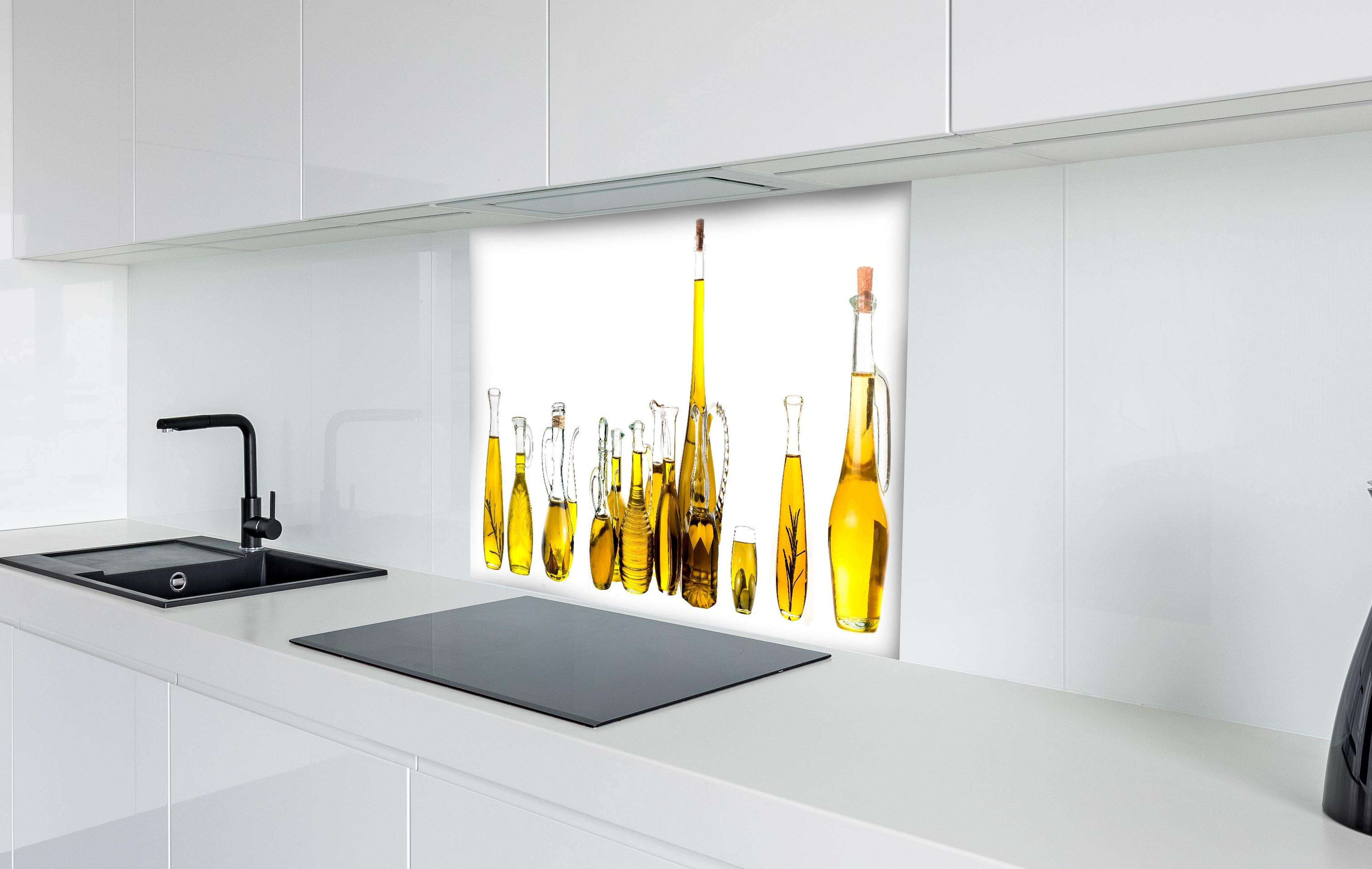Spritzschutz - Elegante Auswahl Gelber Olivenölflaschen hinter einem Cerankochfeld zwischen Holz-Kochutensilien
