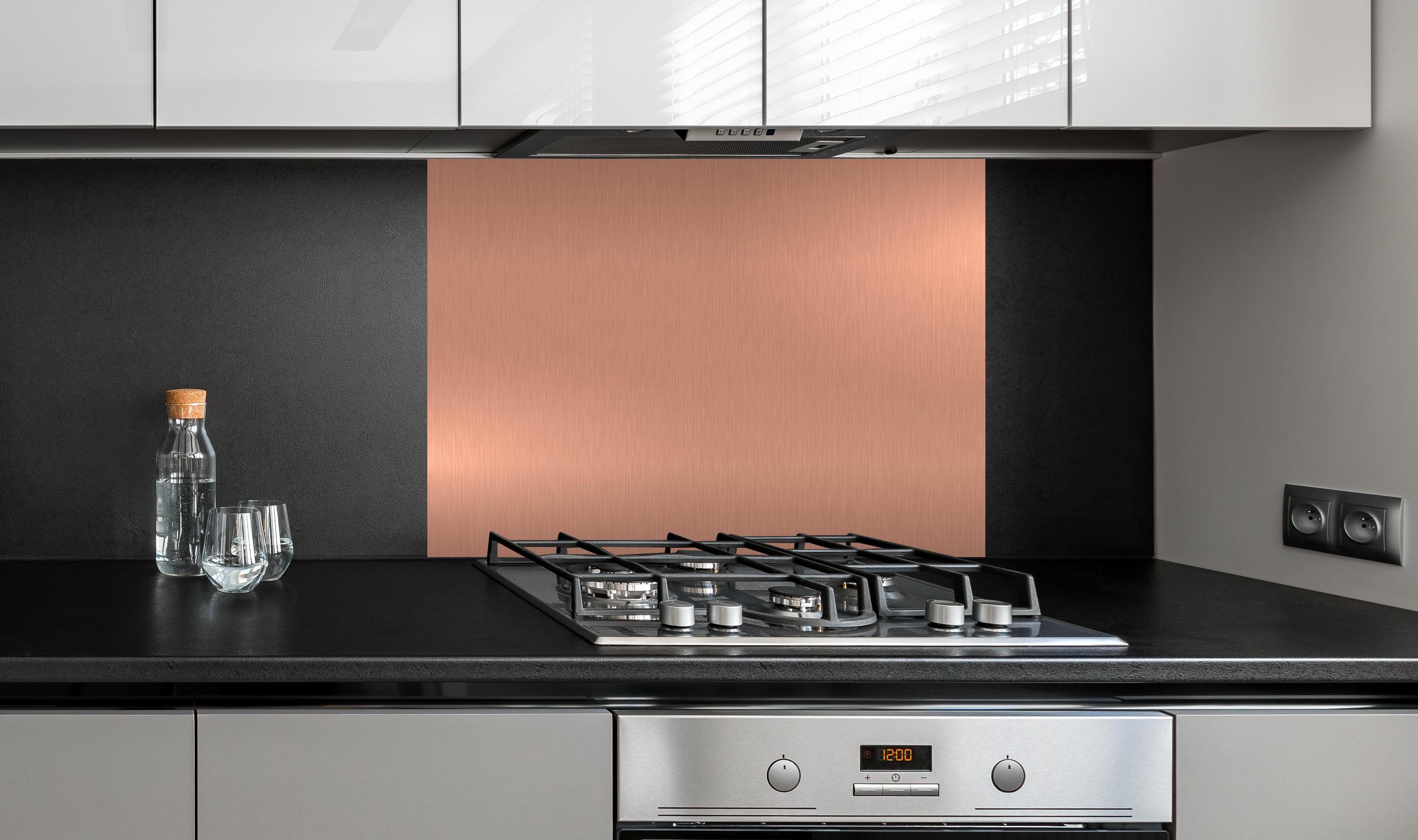 Spritzschutz - Elegante Gebürstete Metall Bronzefarben Struktur hinter einem Cerankochfeld zwischen Holz-Kochutensilien