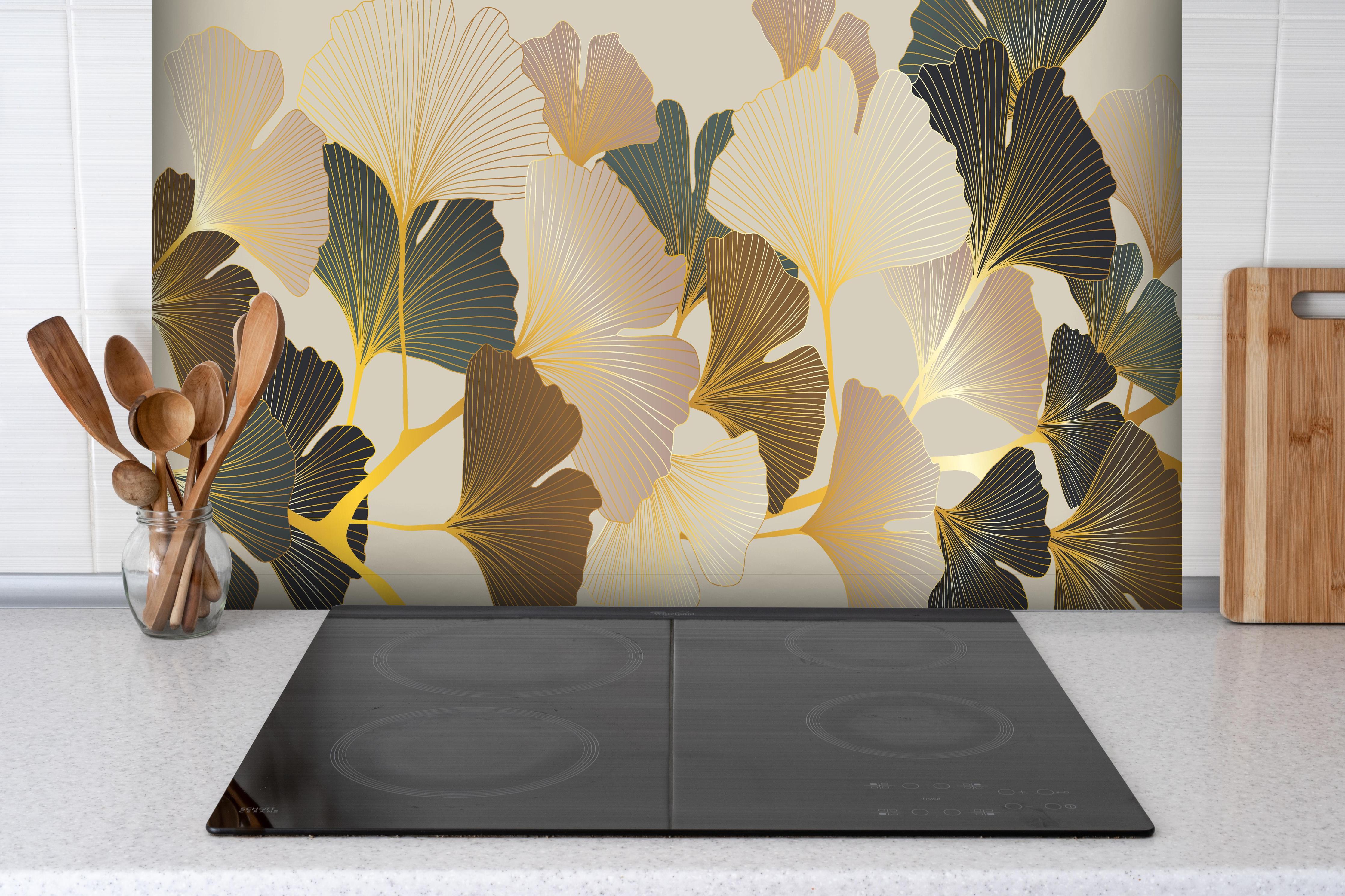 Spritzschutz - Elegante Ginkgo Tapete in Beige Tönen hinter einem Cerankochfeld zwischen Holz-Kochutensilien