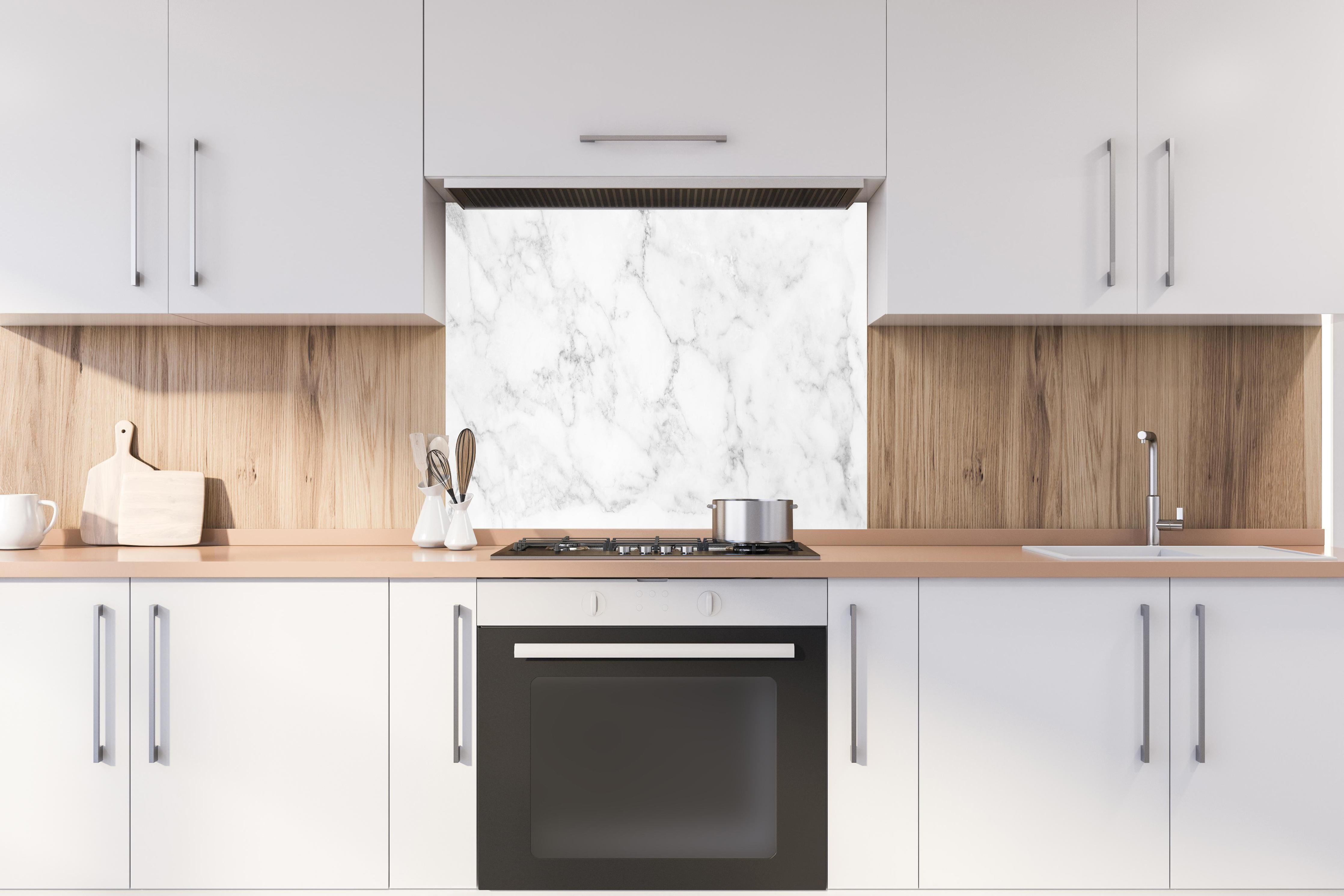 Spritzschutz - Elegante Weiße Marmor Textur hinter einem Cerankochfeld zwischen Holz-Kochutensilien