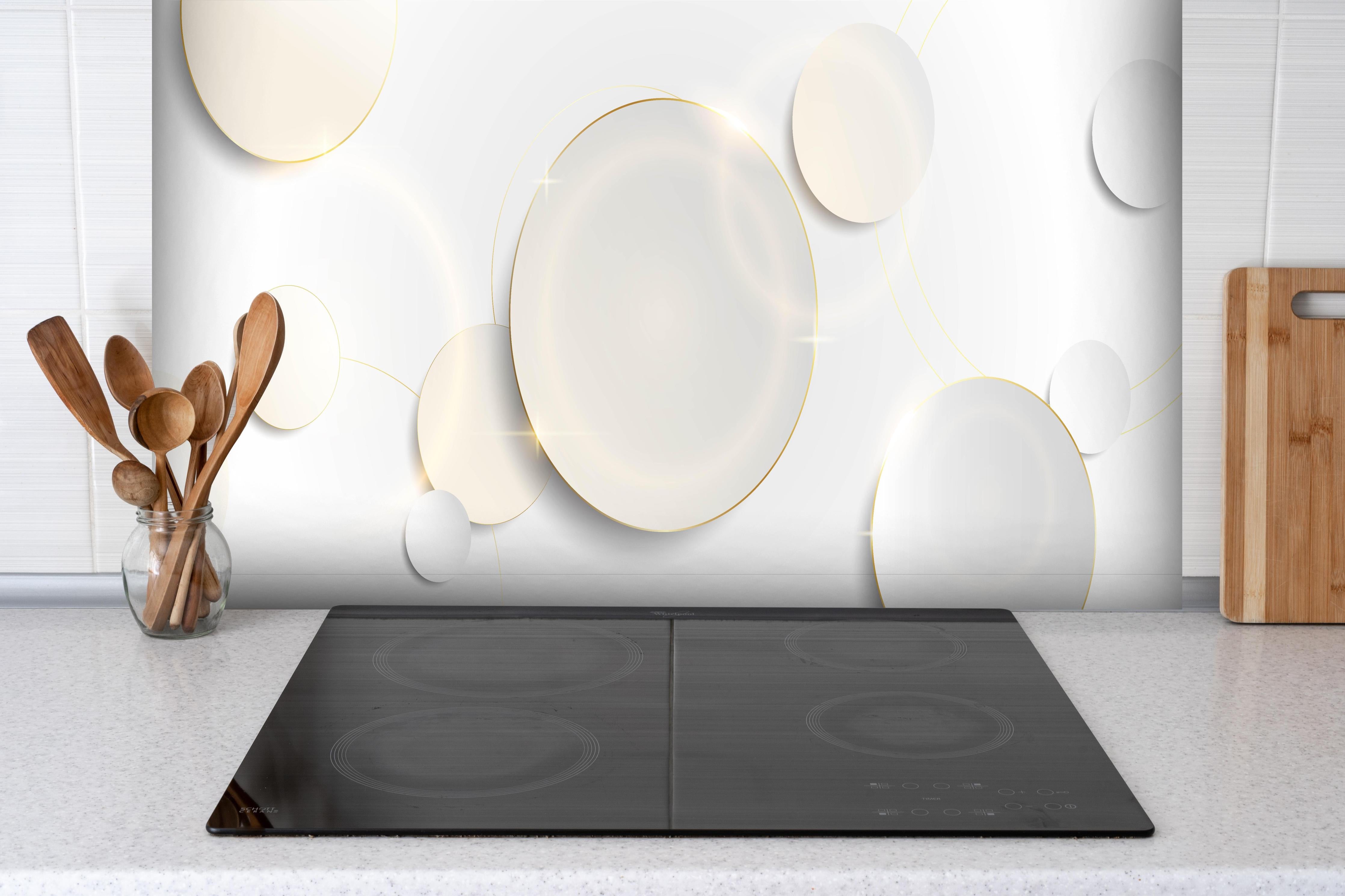 Spritzschutz - Elegante Weiße und Goldene Dekorative Elemente hinter einem Cerankochfeld zwischen Holz-Kochutensilien