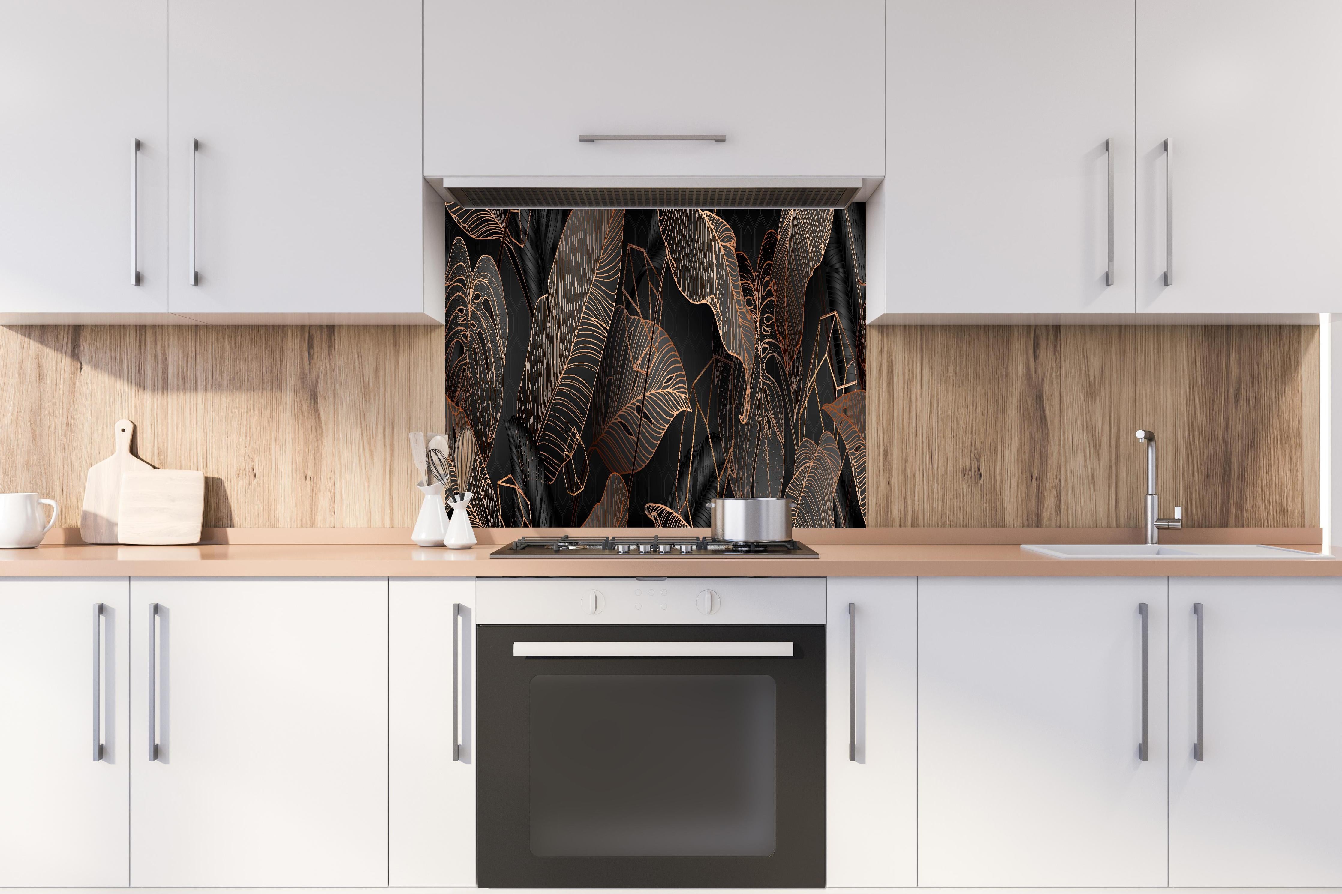 Spritzschutz - Elegante bronzene Blattlinien auf Schwarz hinter einem Cerankochfeld zwischen Holz-Kochutensilien