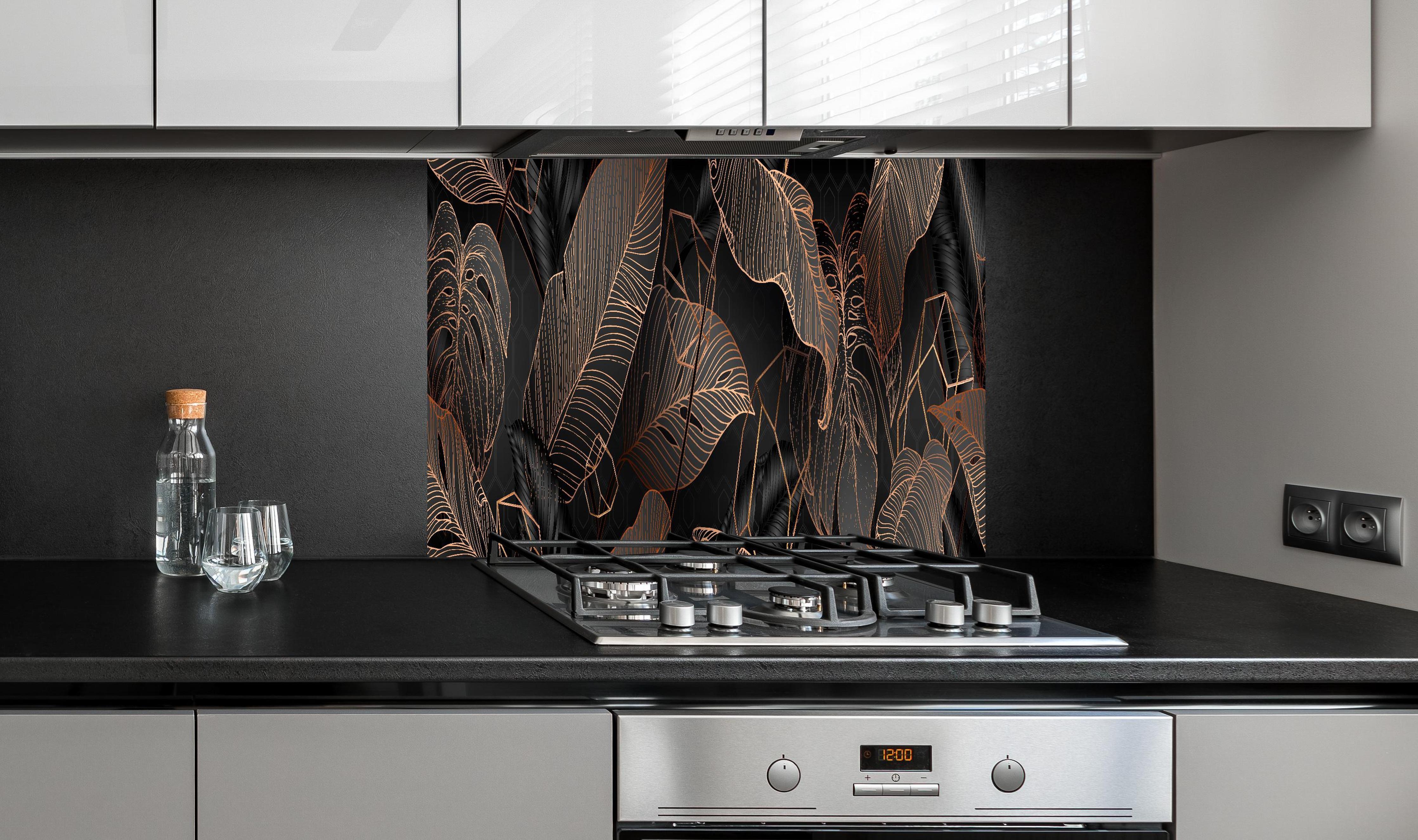 Spritzschutz - Elegante bronzene Blattlinien auf Schwarz hinter einem Cerankochfeld zwischen Holz-Kochutensilien