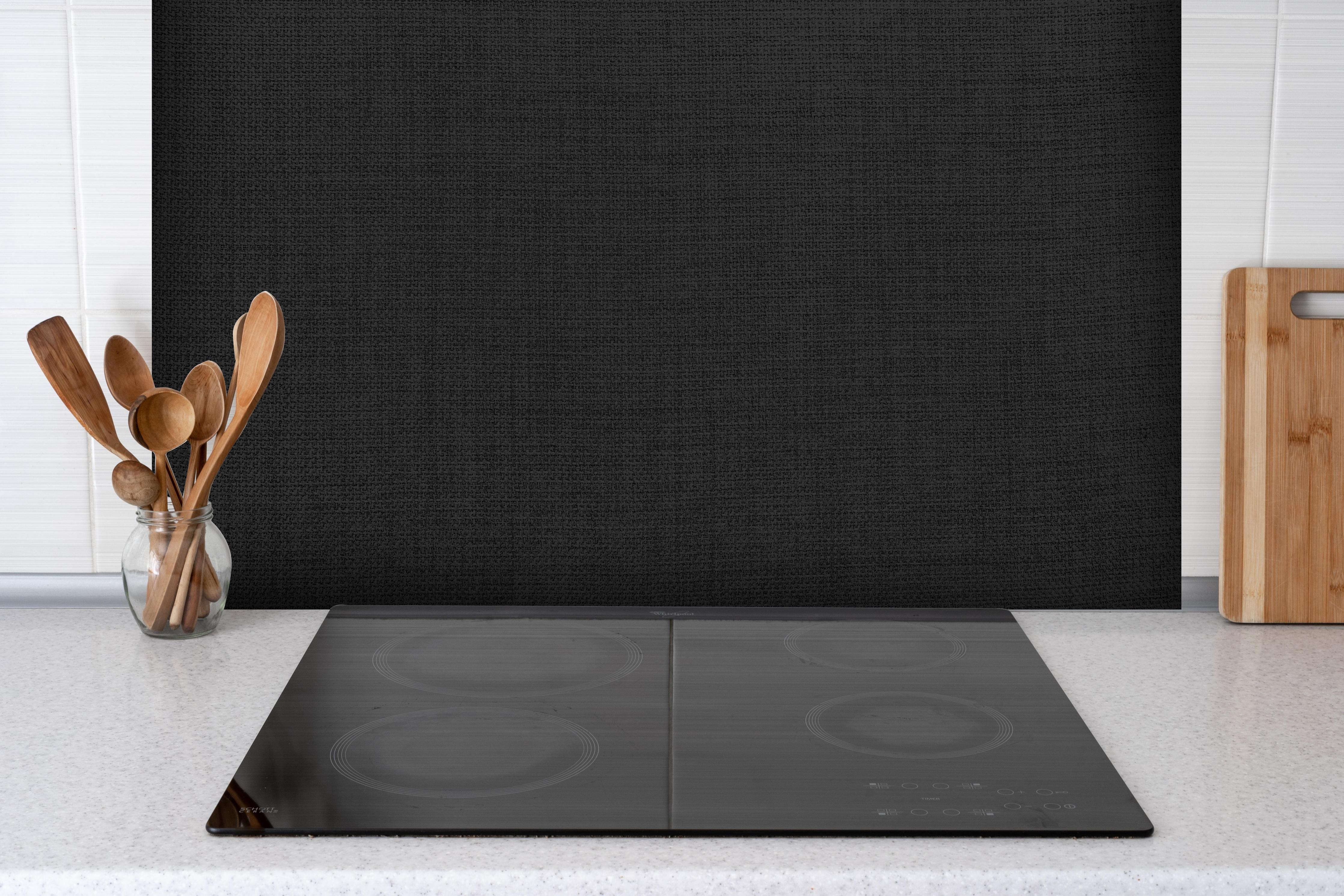 Spritzschutz - Elegante monochrome Grauton Wandtextur hinter einem Cerankochfeld zwischen Holz-Kochutensilien