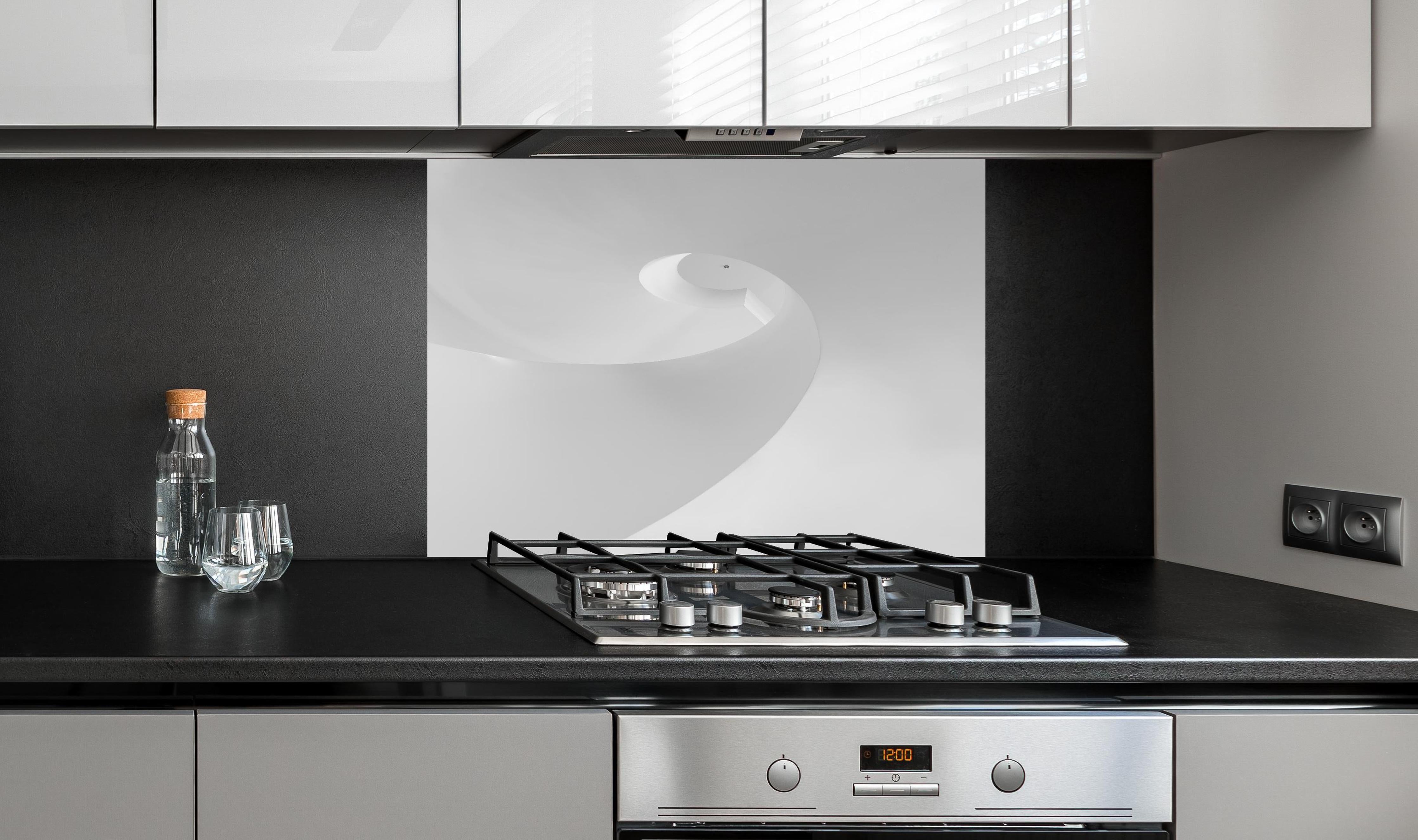 Spritzschutz - Elegante monochrome Spirale in Schwarz-weiß hinter einem Cerankochfeld zwischen Holz-Kochutensilien