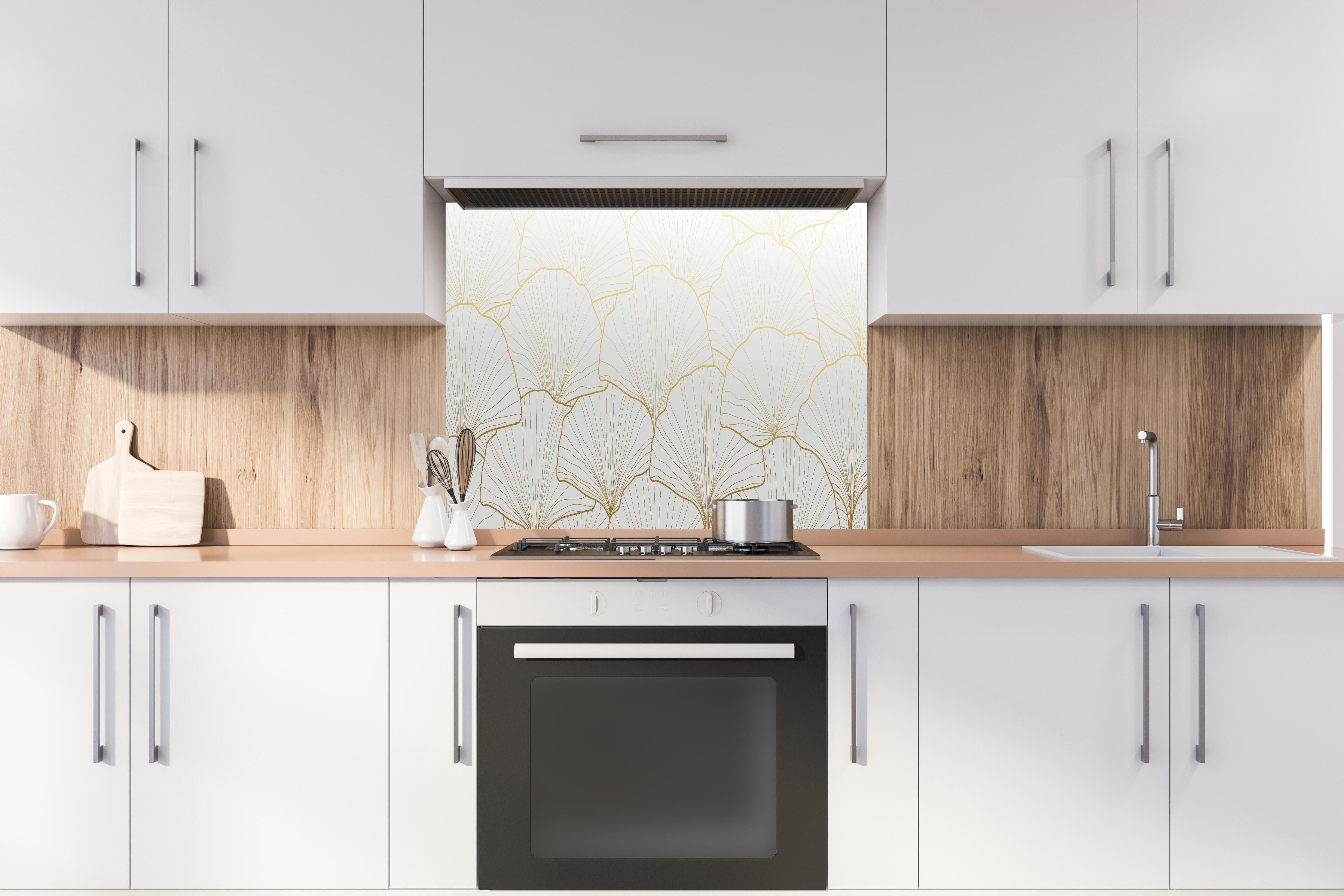Spritzschutz - Elegante weiße Ginkgo Blattgold Textur hinter einem Cerankochfeld zwischen Holz-Kochutensilien
