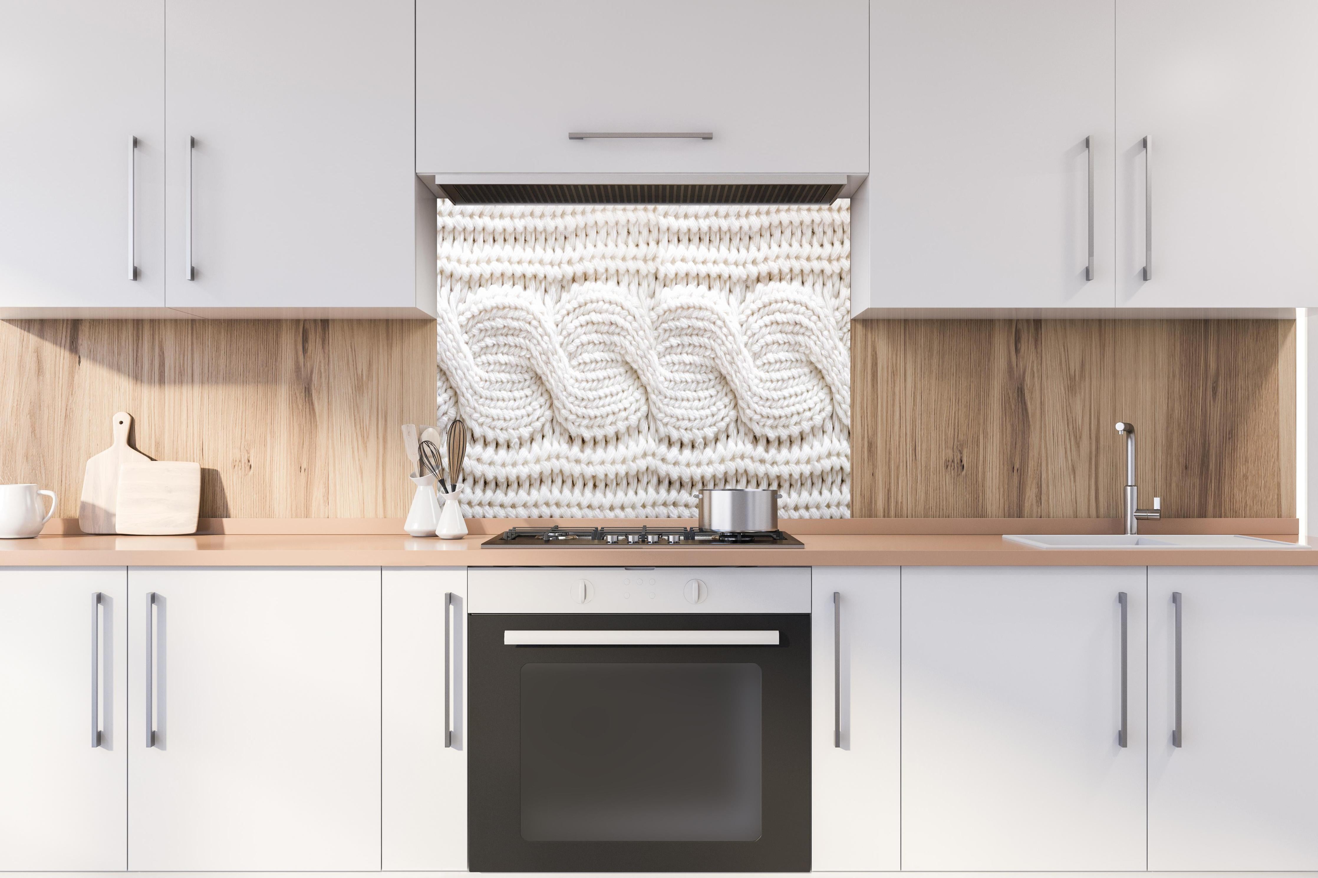 Spritzschutz - Elegante weiße Stricktextur aus Wolle hinter einem Cerankochfeld zwischen Holz-Kochutensilien