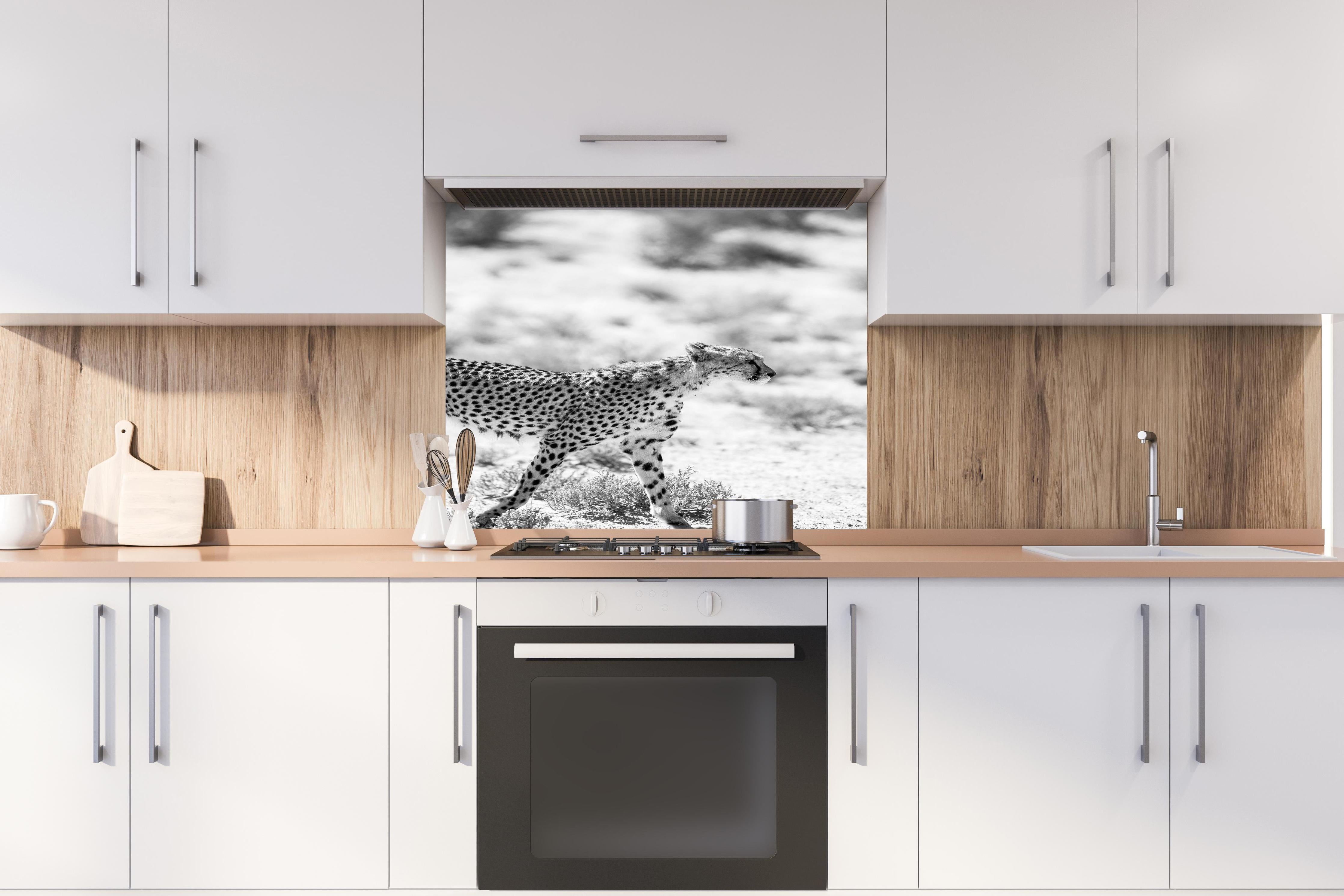 Spritzschutz - Eleganter Gepard in monochromer Darstellung hinter einem Cerankochfeld zwischen Holz-Kochutensilien