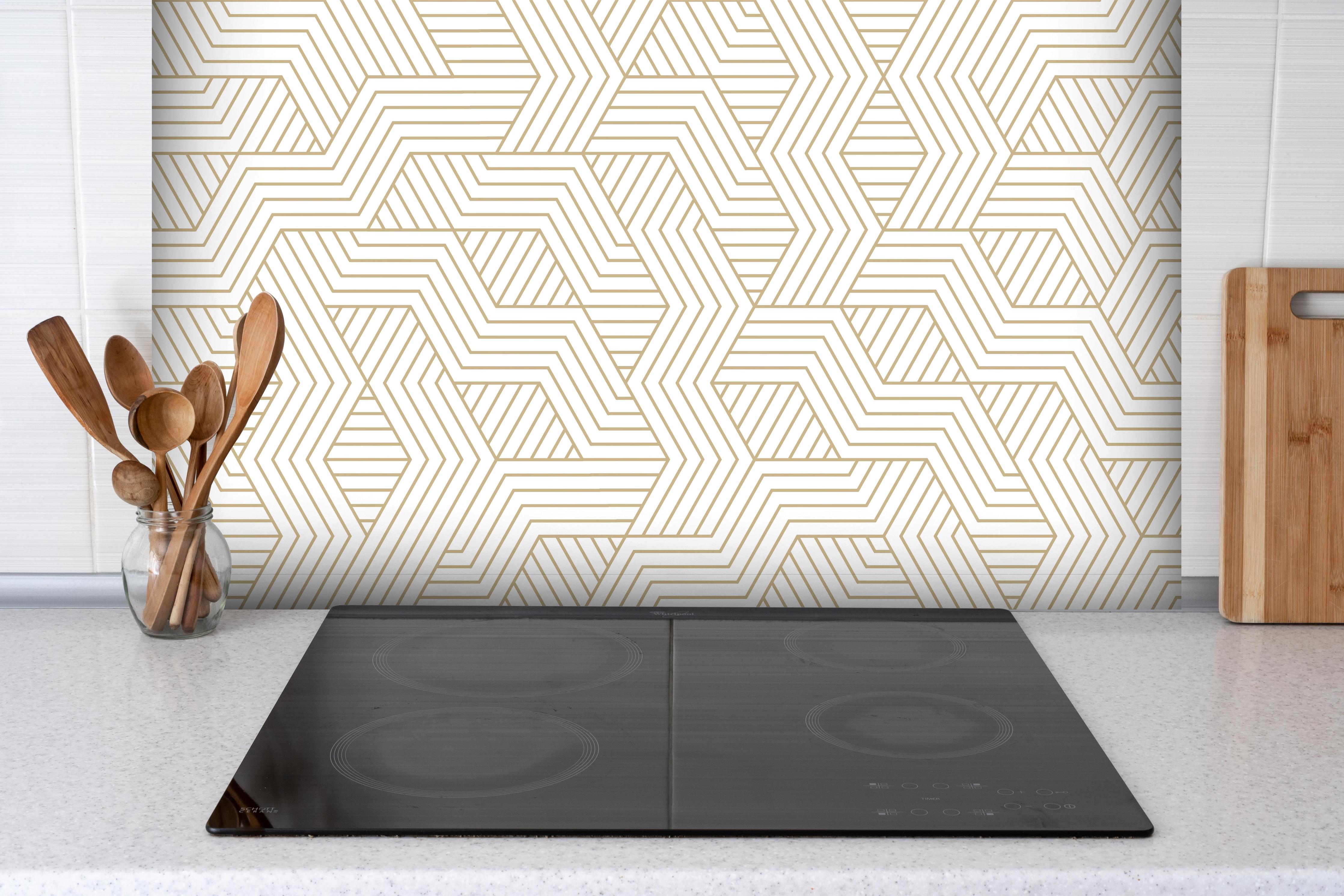 Spritzschutz - Eleganter Hintergrund mit geometrischem Gold und Weiß hinter einem Cerankochfeld zwischen Holz-Kochutensilien