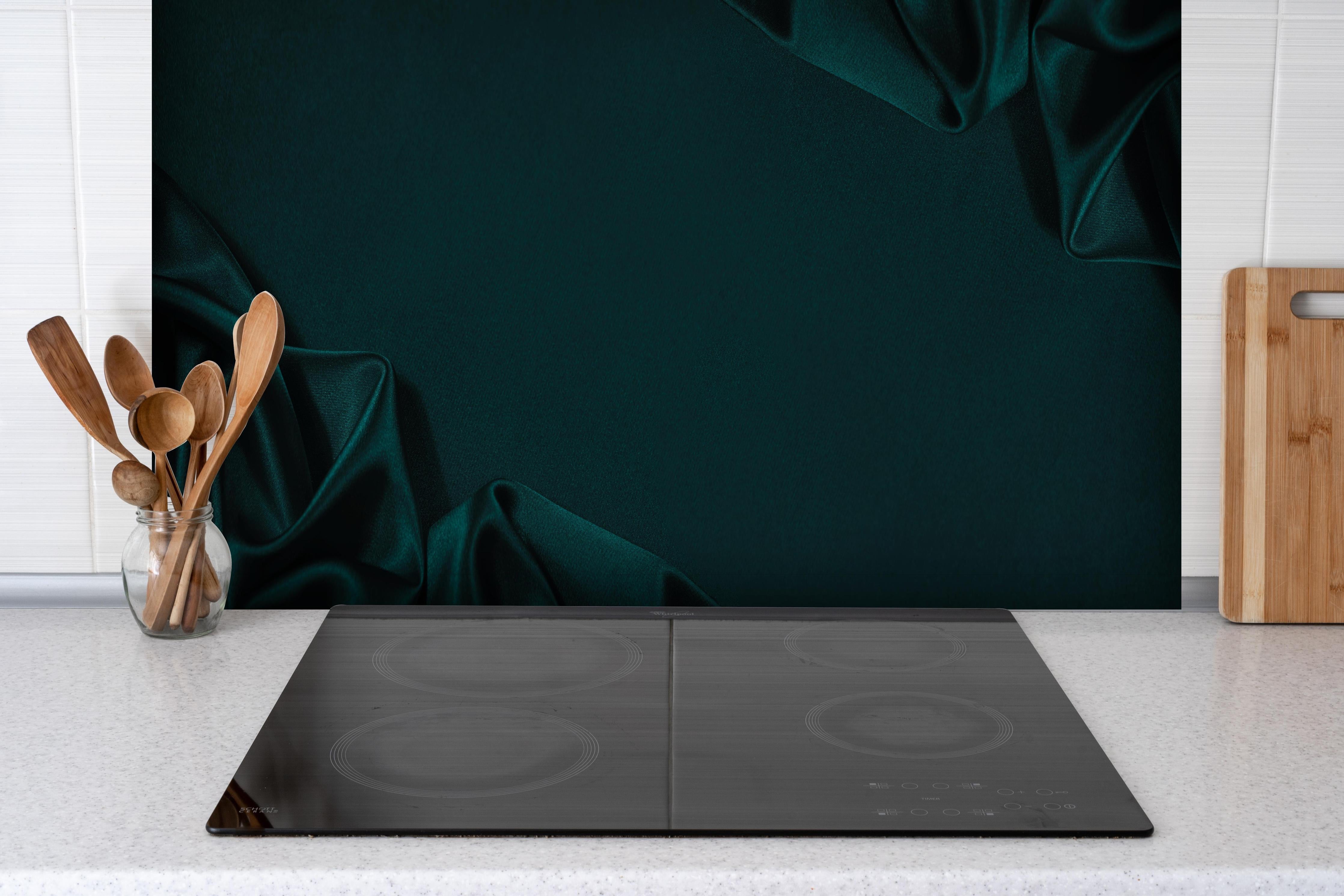 Spritzschutz - Eleganter dunkelblauer Seidensatin Hintergrund hinter einem Cerankochfeld zwischen Holz-Kochutensilien