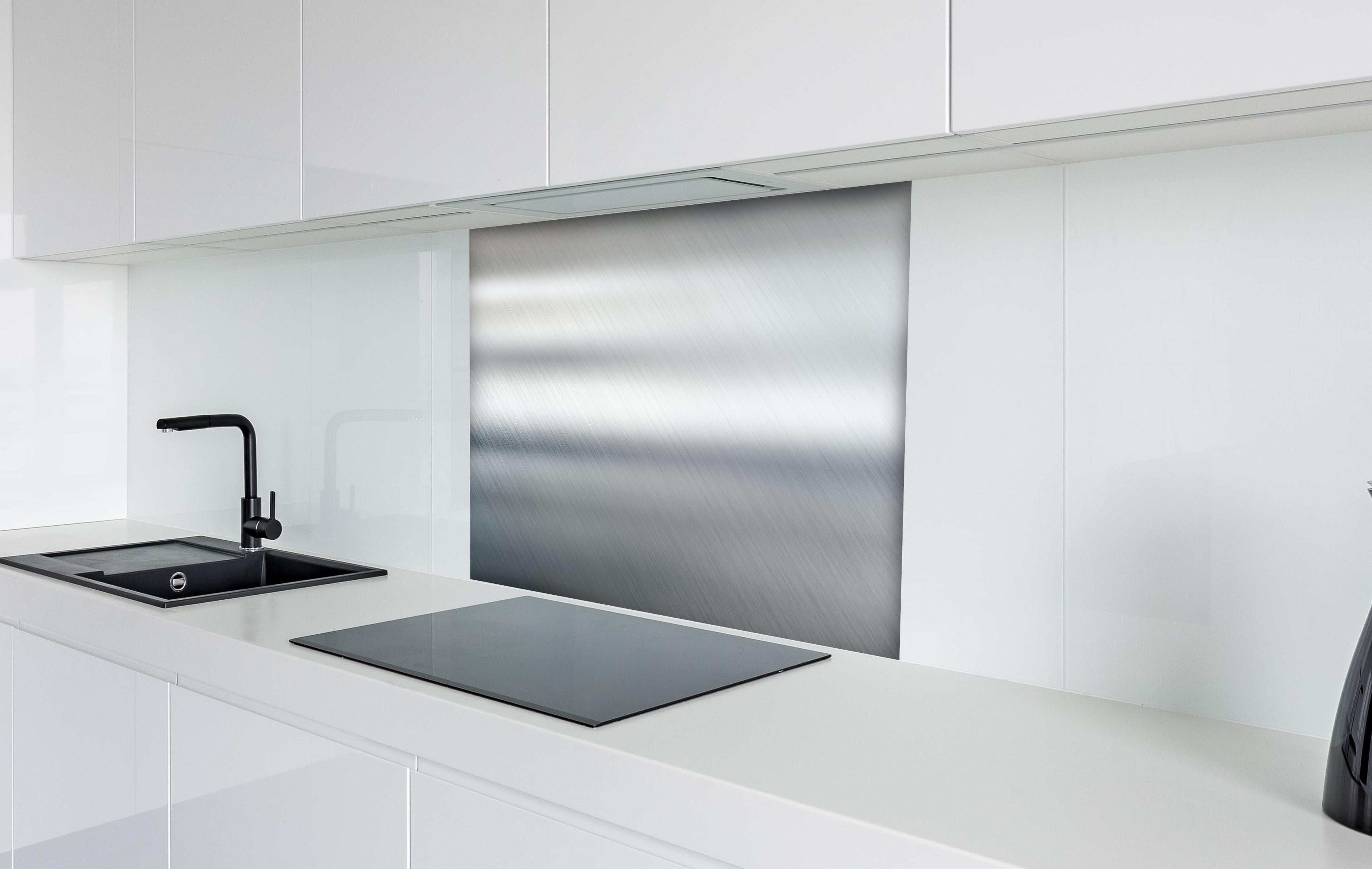 Spritzschutz - Eleganter gebürsteter Metall Hintergrund hinter einem Cerankochfeld zwischen Holz-Kochutensilien