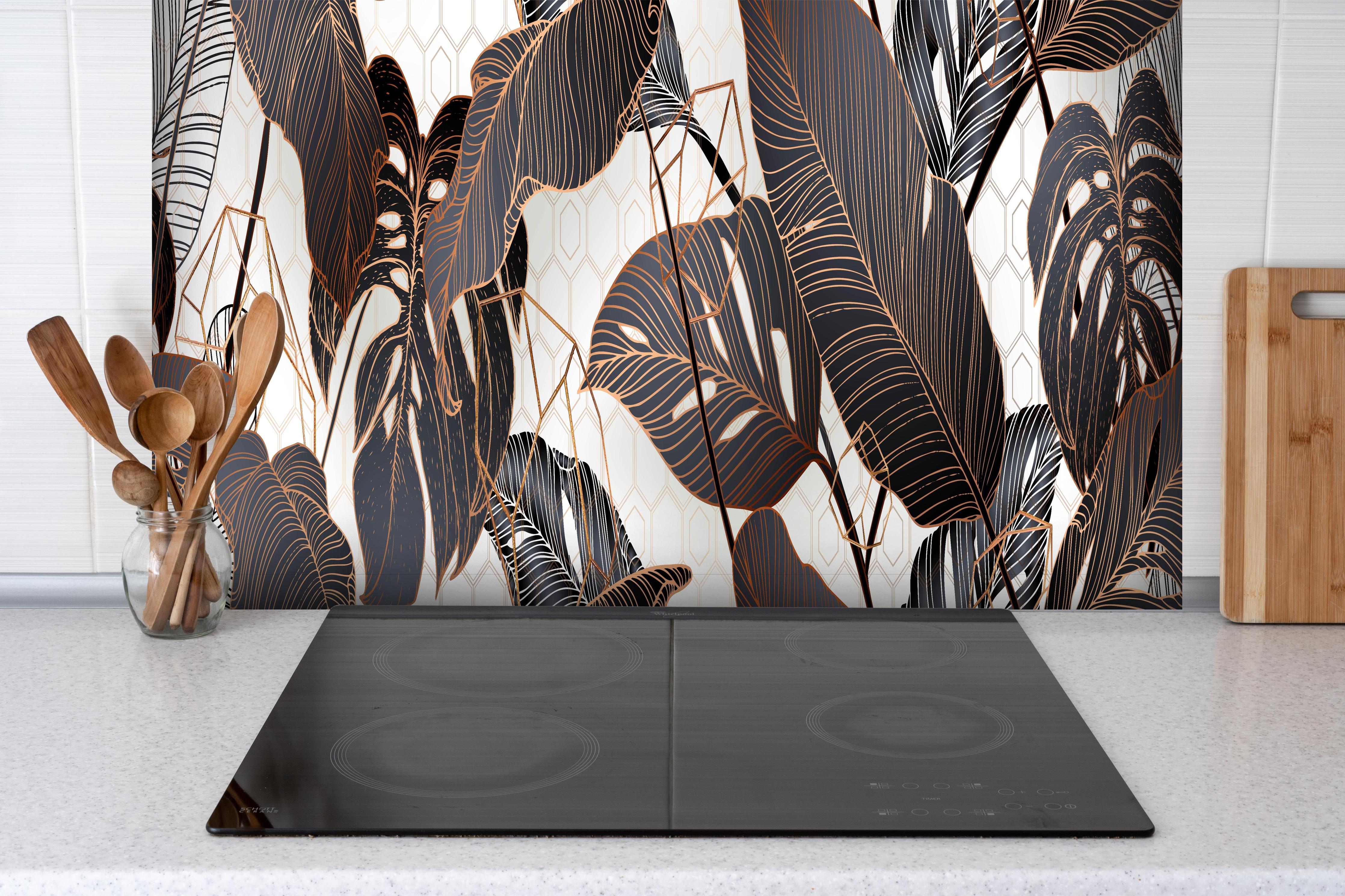Spritzschutz - Elegantes Blättermuster in Erdtönen hinter einem Cerankochfeld zwischen Holz-Kochutensilien