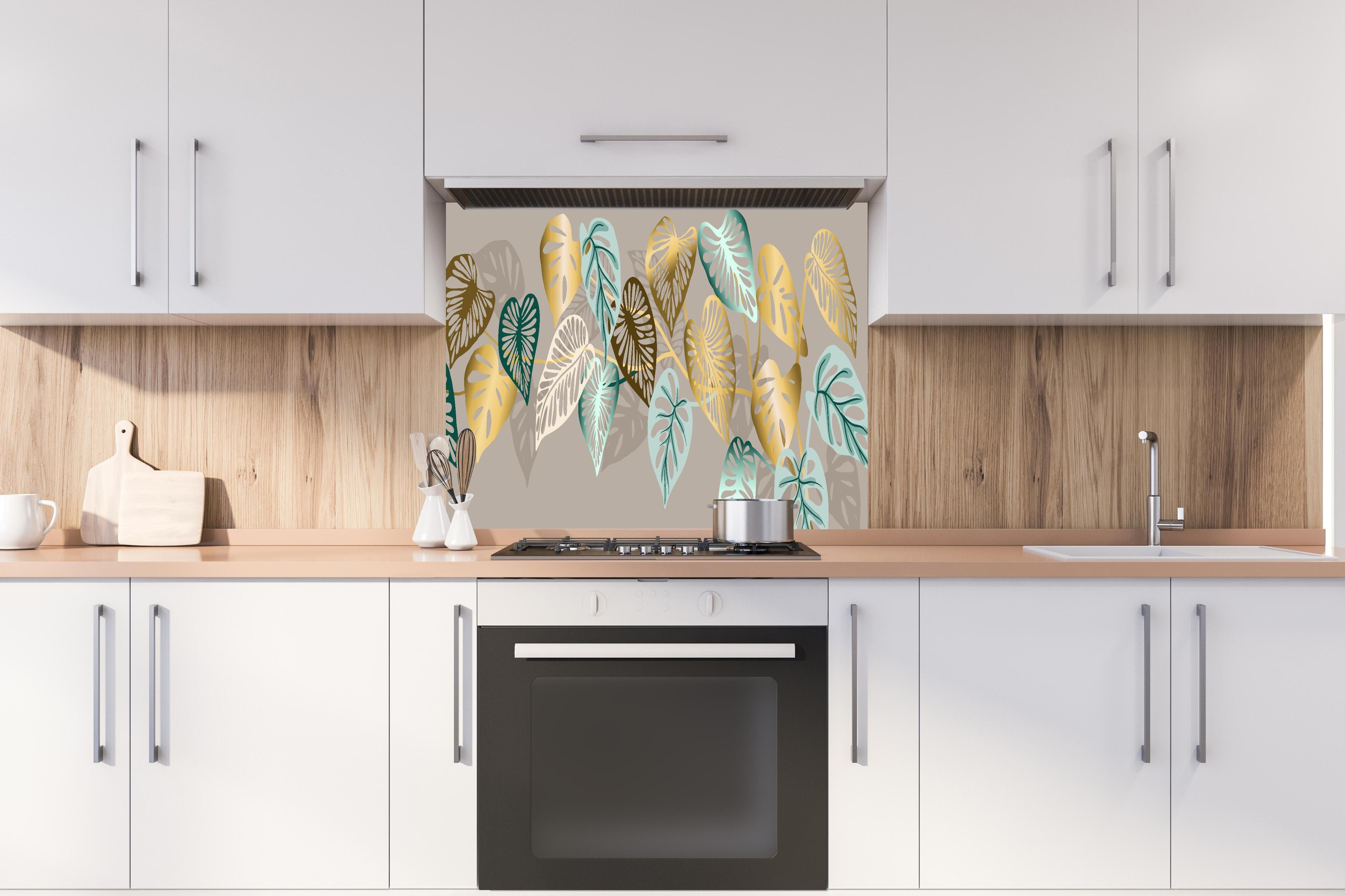 Spritzschutz - Elegantes Blattmuster in Goldtönen hinter einem Cerankochfeld zwischen Holz-Kochutensilien