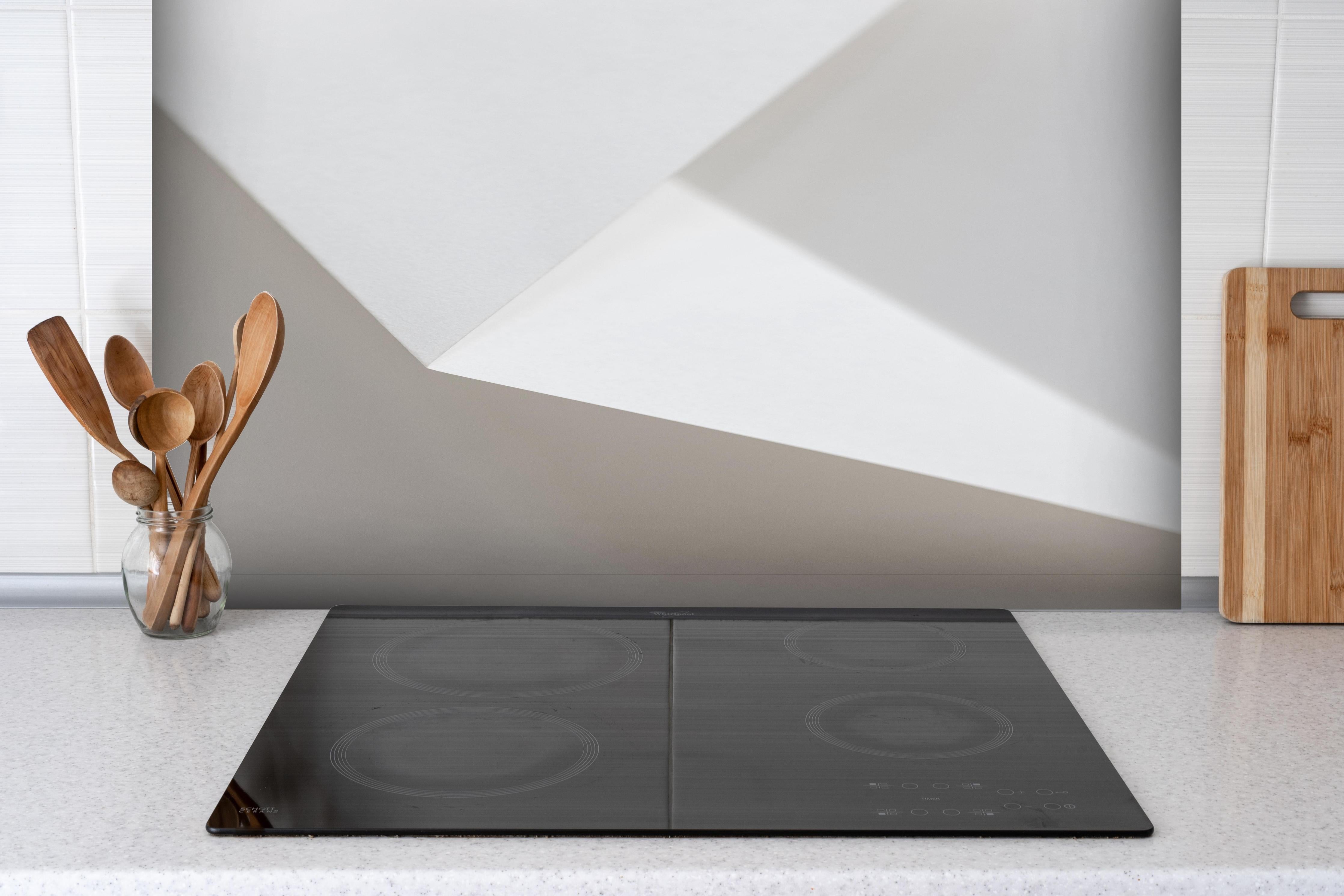 Spritzschutz - Elegantes Design Weiß und Schatten-Textur hinter einem Cerankochfeld zwischen Holz-Kochutensilien