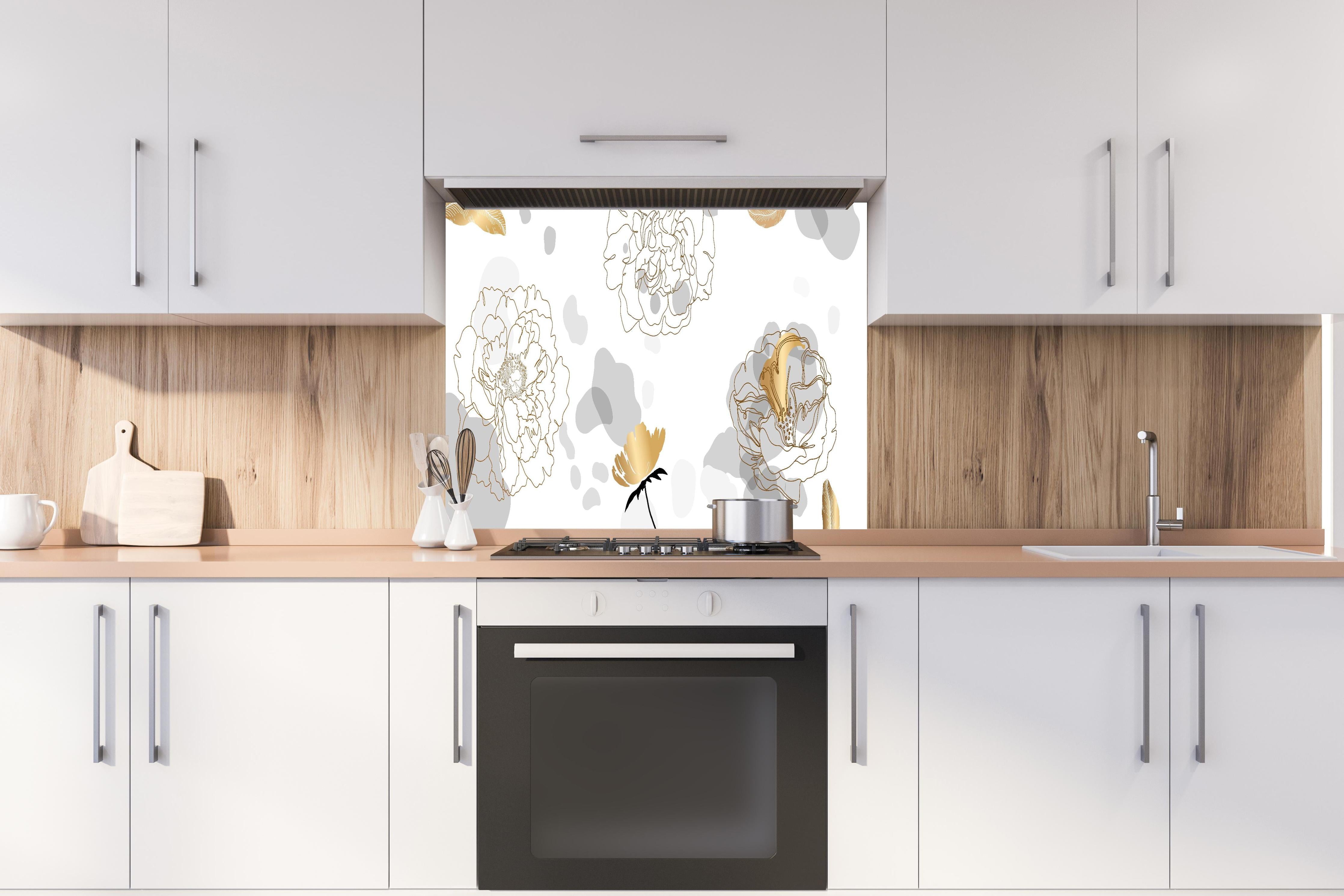 Spritzschutz - Elegantes florales Muster in Goldweiß hinter einem Cerankochfeld zwischen Holz-Kochutensilien