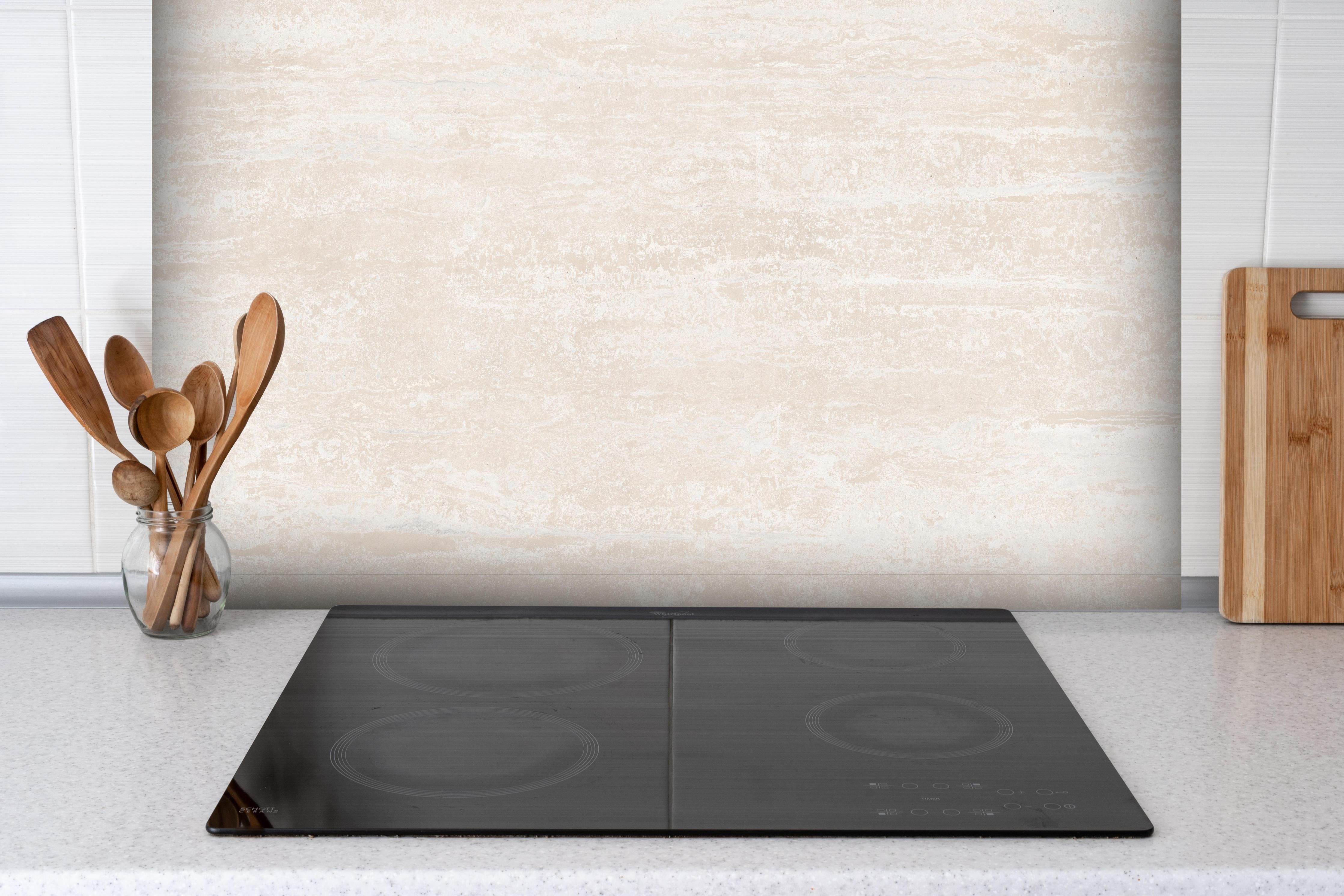 Spritzschutz - Elfenbein beige Marmor hinter einem Cerankochfeld zwischen Holz-Kochutensilien