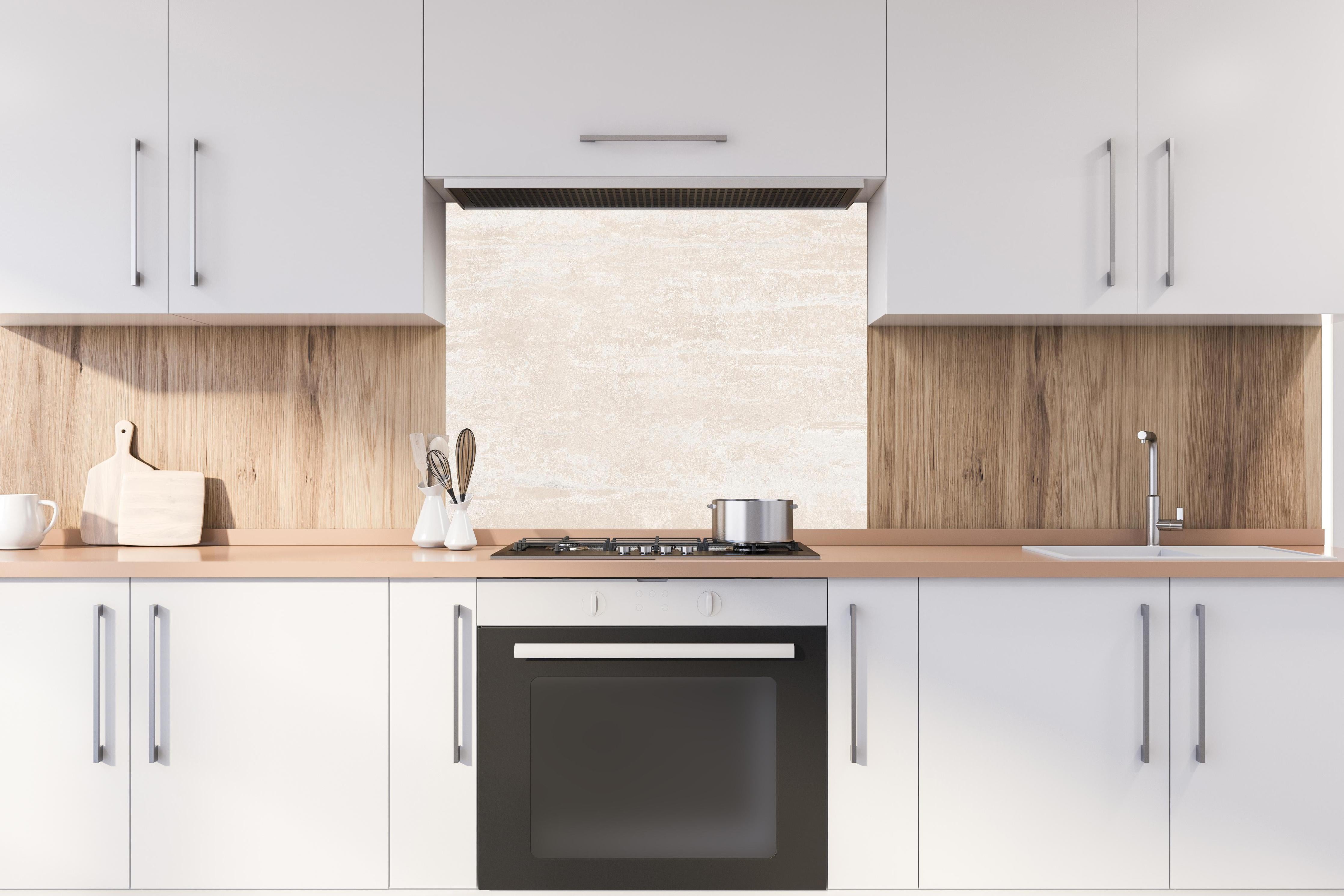 Spritzschutz - Elfenbein beige Marmor hinter einem Cerankochfeld zwischen Holz-Kochutensilien