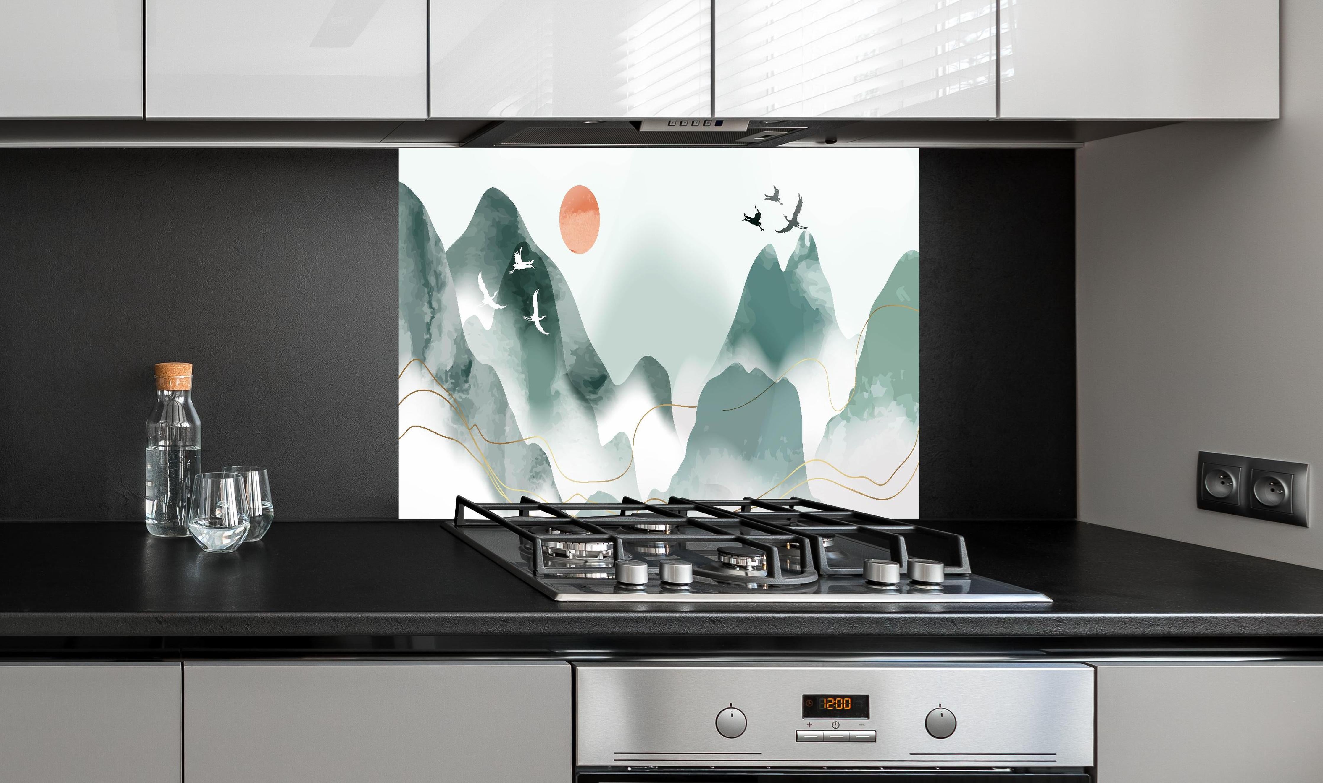 Spritzschutz - Entspannende Berglandschaft bei Sonnenuntergang hinter einem Cerankochfeld zwischen Holz-Kochutensilien