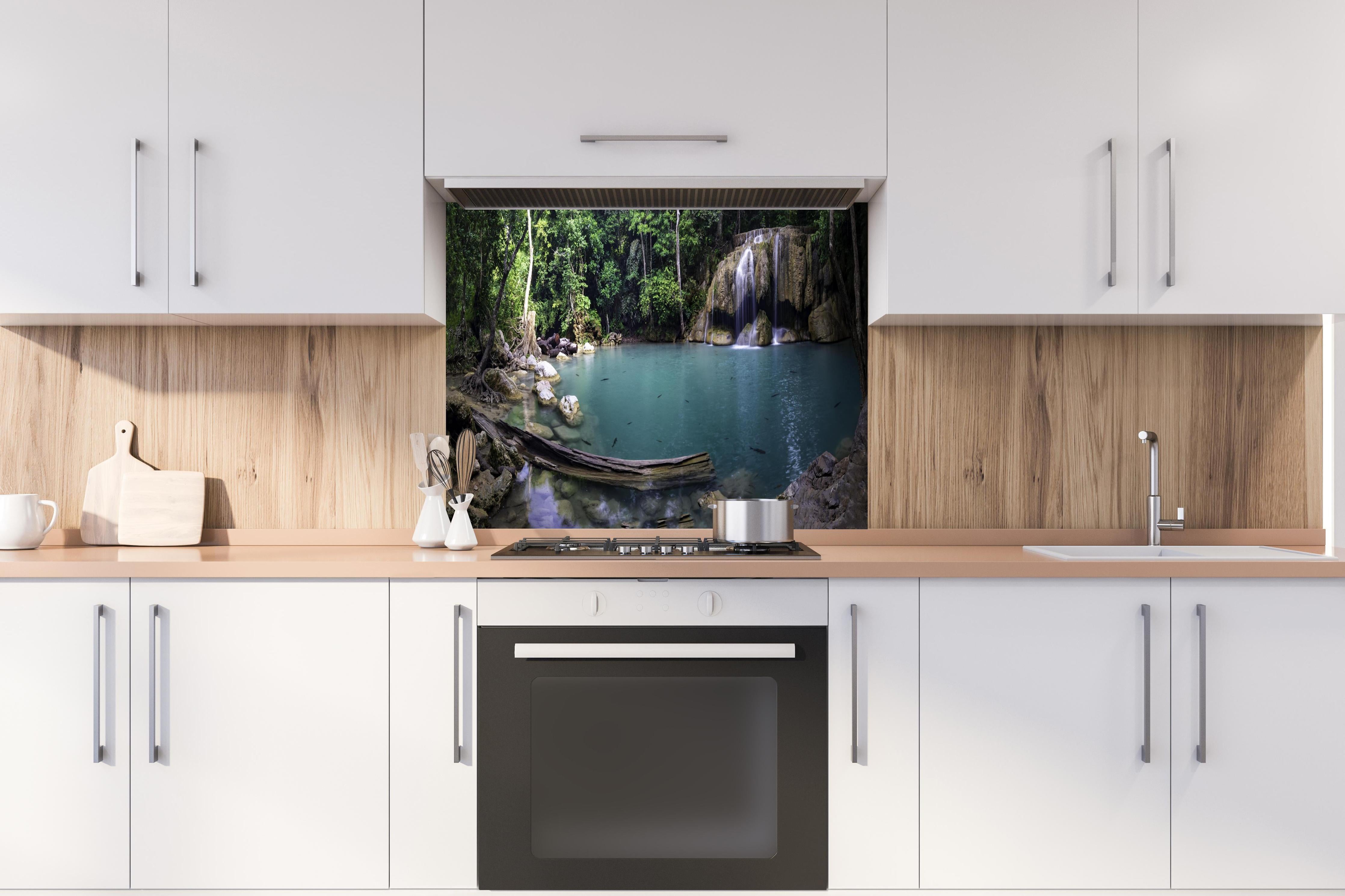 Spritzschutz - Erawan-Wasserfall im tropischen Dschungel Surrou hinter einem Cerankochfeld zwischen Holz-Kochutensilien