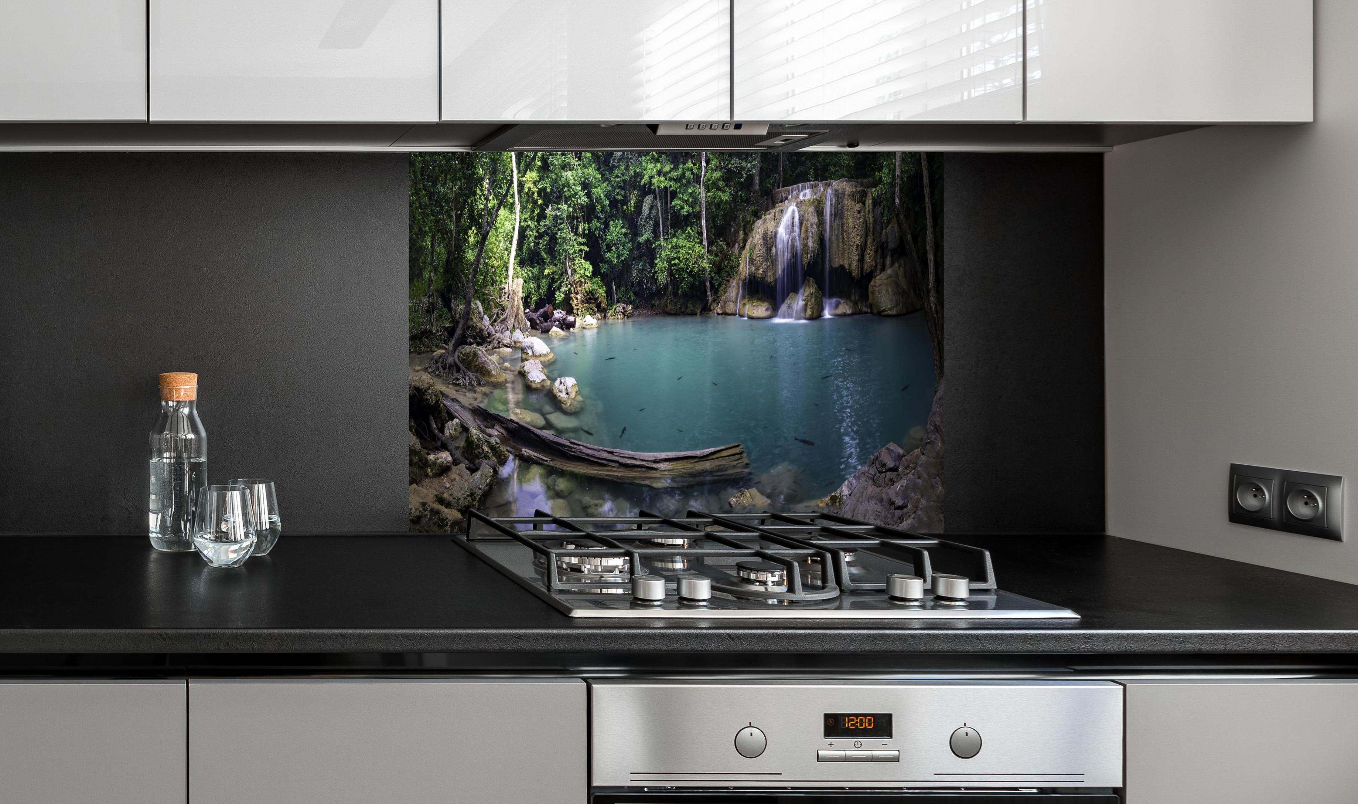 Spritzschutz - Erawan-Wasserfall im tropischen Dschungel Surrou hinter einem Cerankochfeld zwischen Holz-Kochutensilien