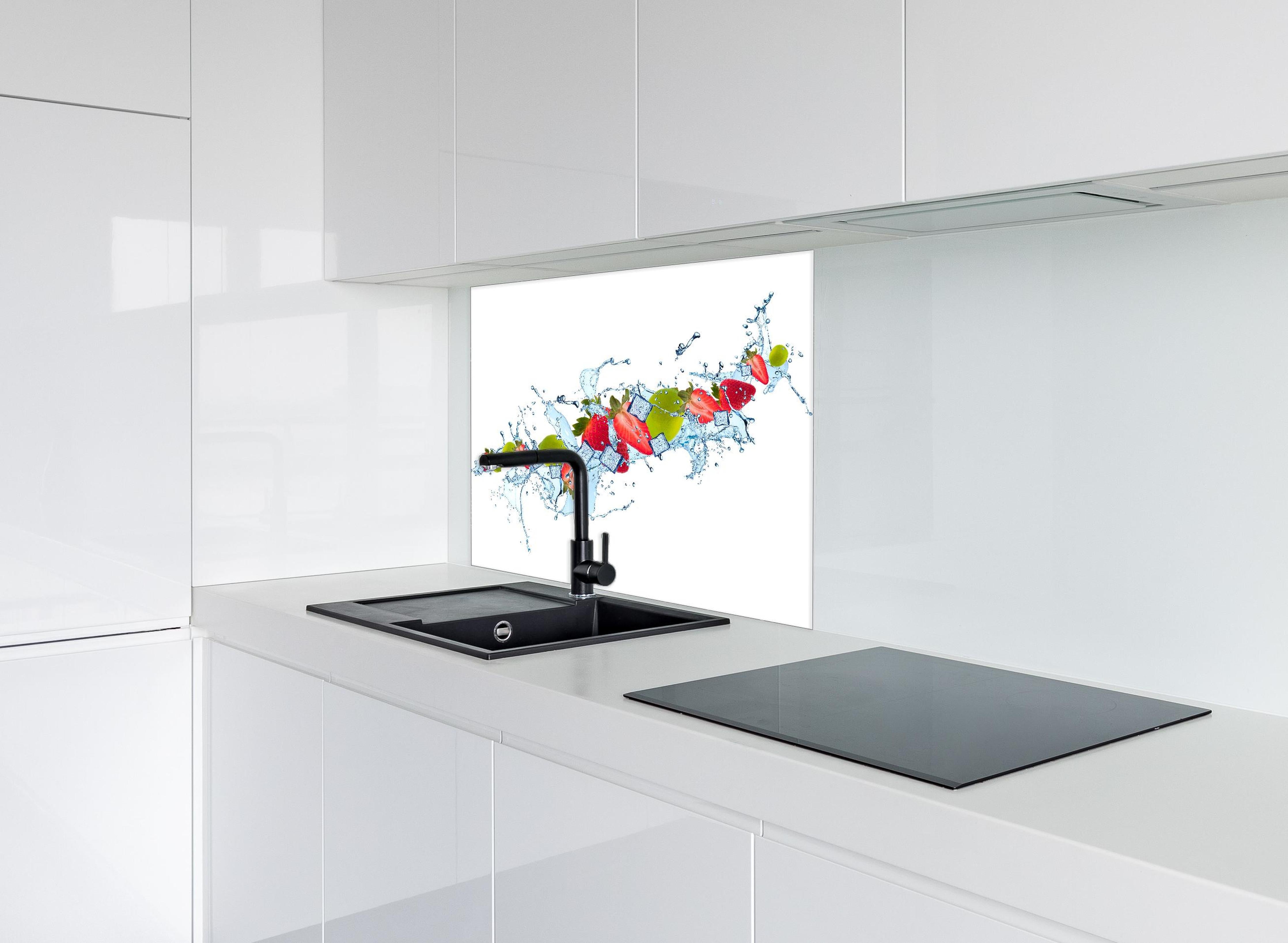 Spritzschutz - Erfrischende Wasserspritzer mit Erdbeere und Limette hinter einem Cerankochfeld zwischen Holz-Kochutensilien