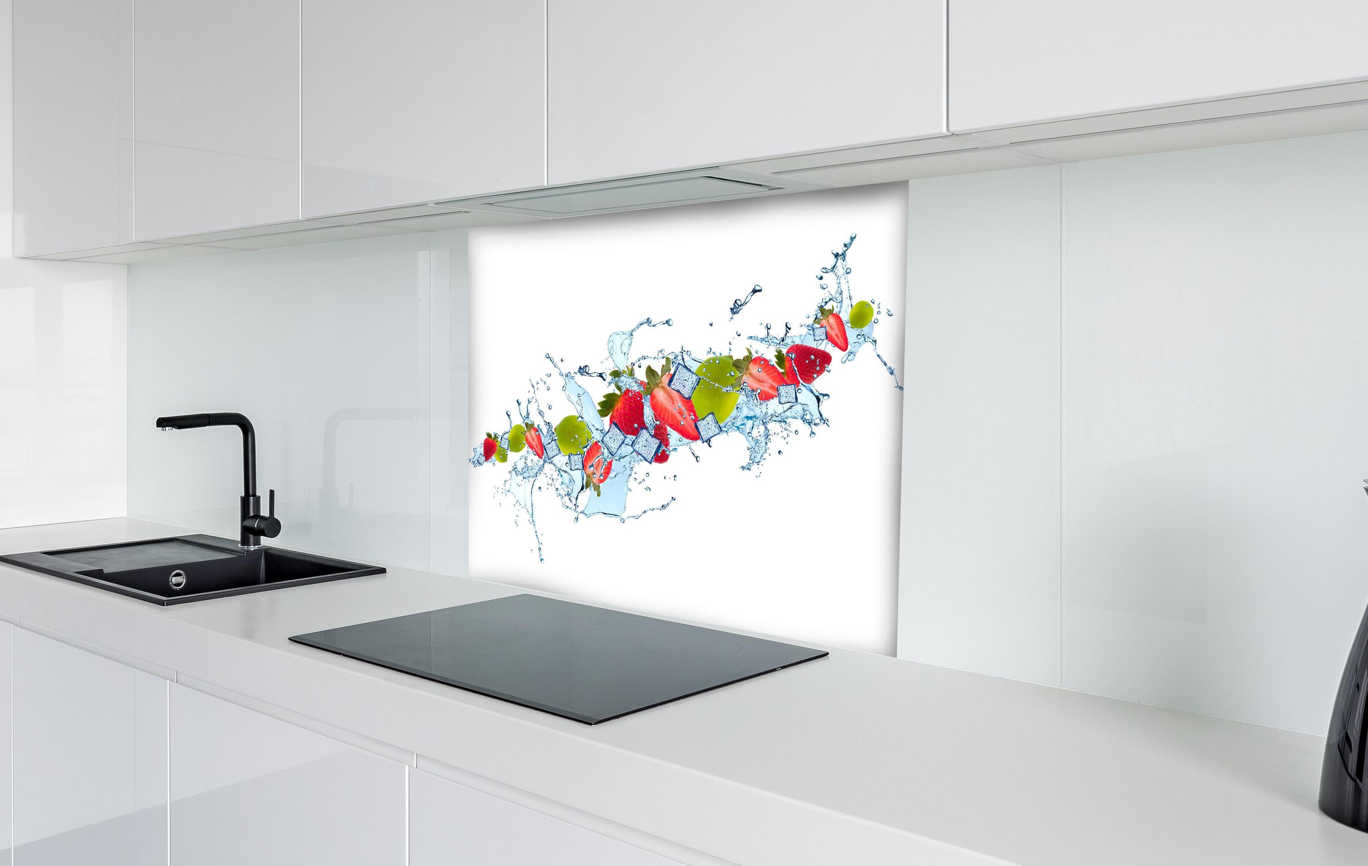 Spritzschutz - Erfrischende Wasserspritzer mit Erdbeere und Limette hinter einem Cerankochfeld zwischen Holz-Kochutensilien