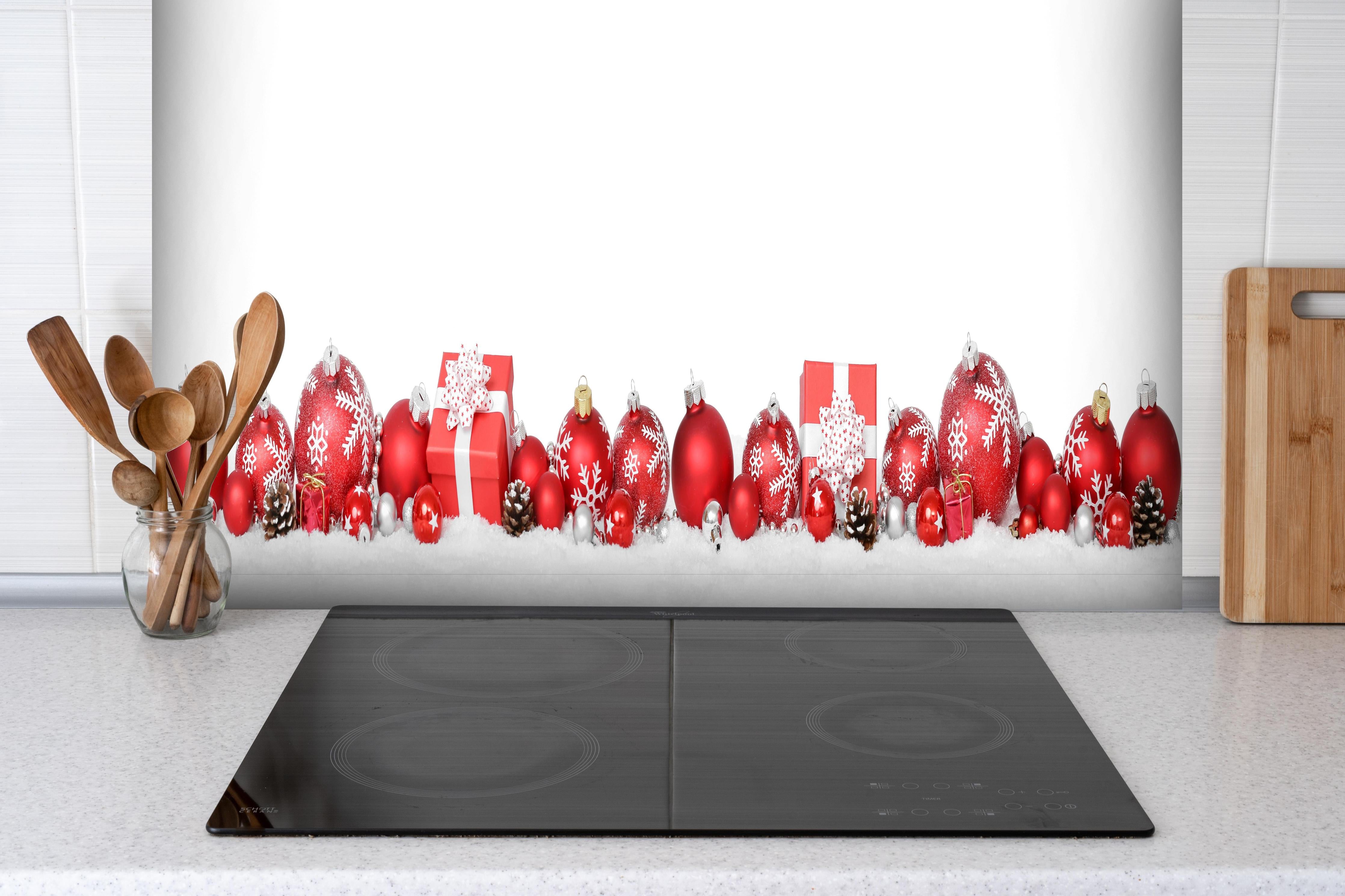 Spritzschutz - Exklusive Weihnachtsdeko in Rot und Weiß hinter einem Cerankochfeld zwischen Holz-Kochutensilien