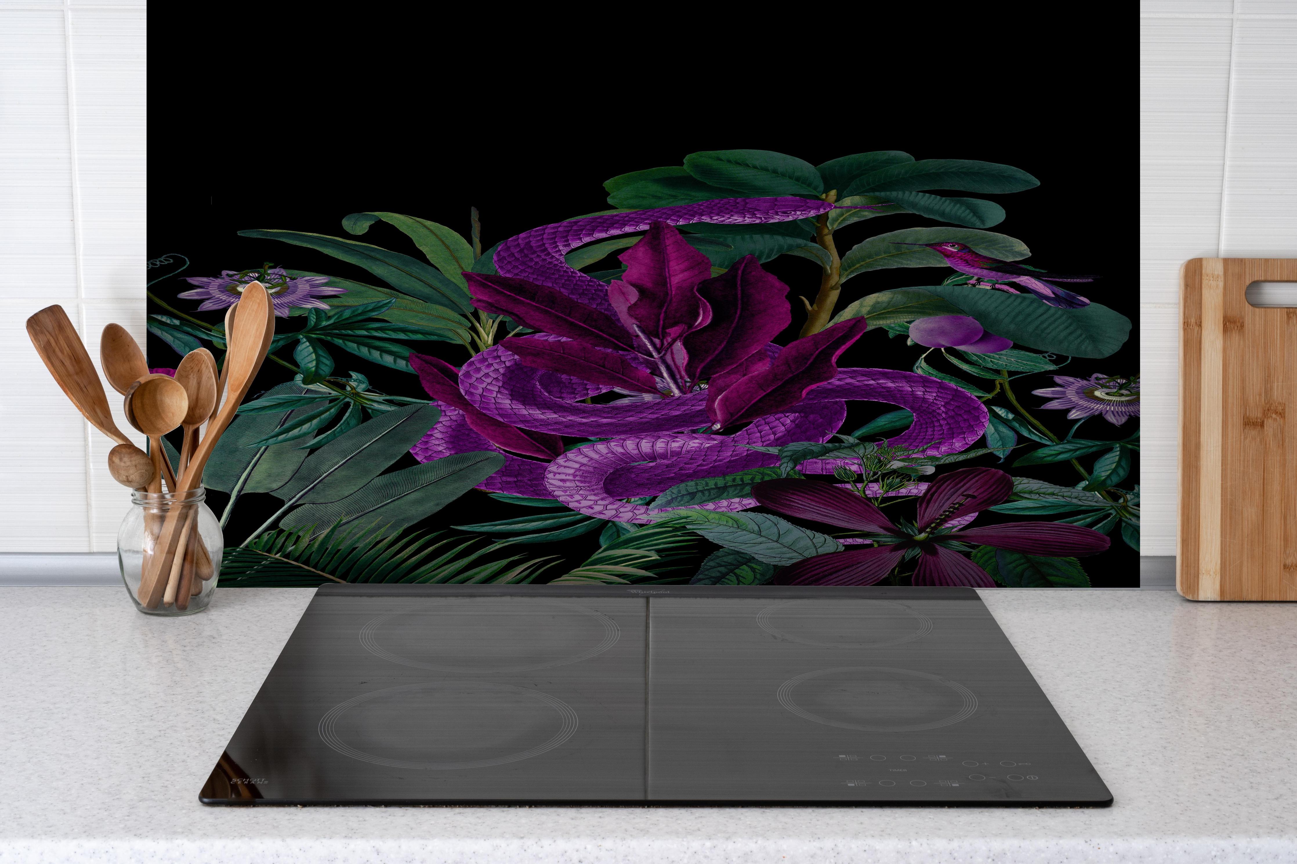 Spritzschutz - Exotischer Schlangenprint in Lila und Grün hinter einem Cerankochfeld zwischen Holz-Kochutensilien