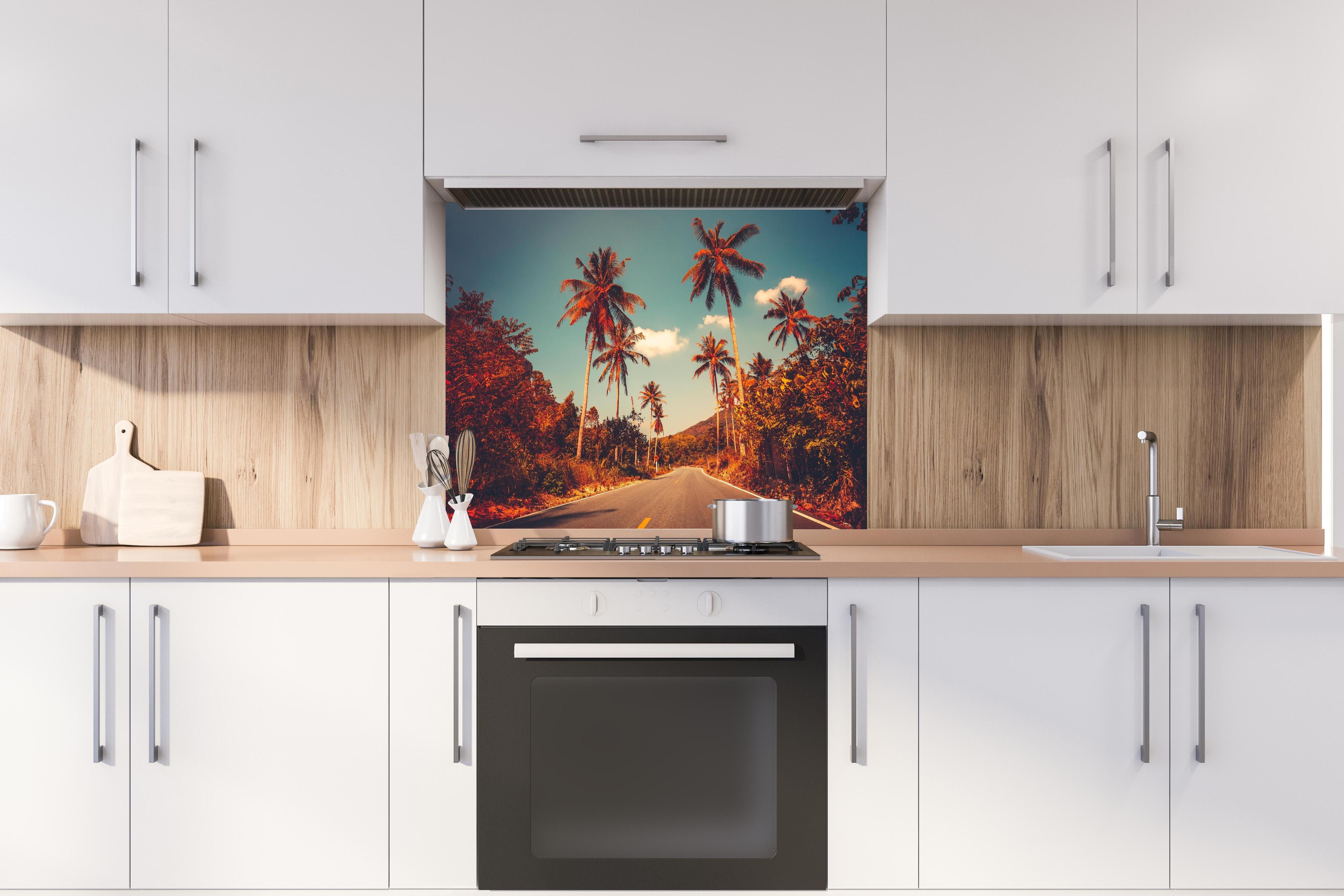 Spritzschutz - Exotischer Sonnenuntergang Palmenlandschaft Bild hinter einem Cerankochfeld zwischen Holz-Kochutensilien