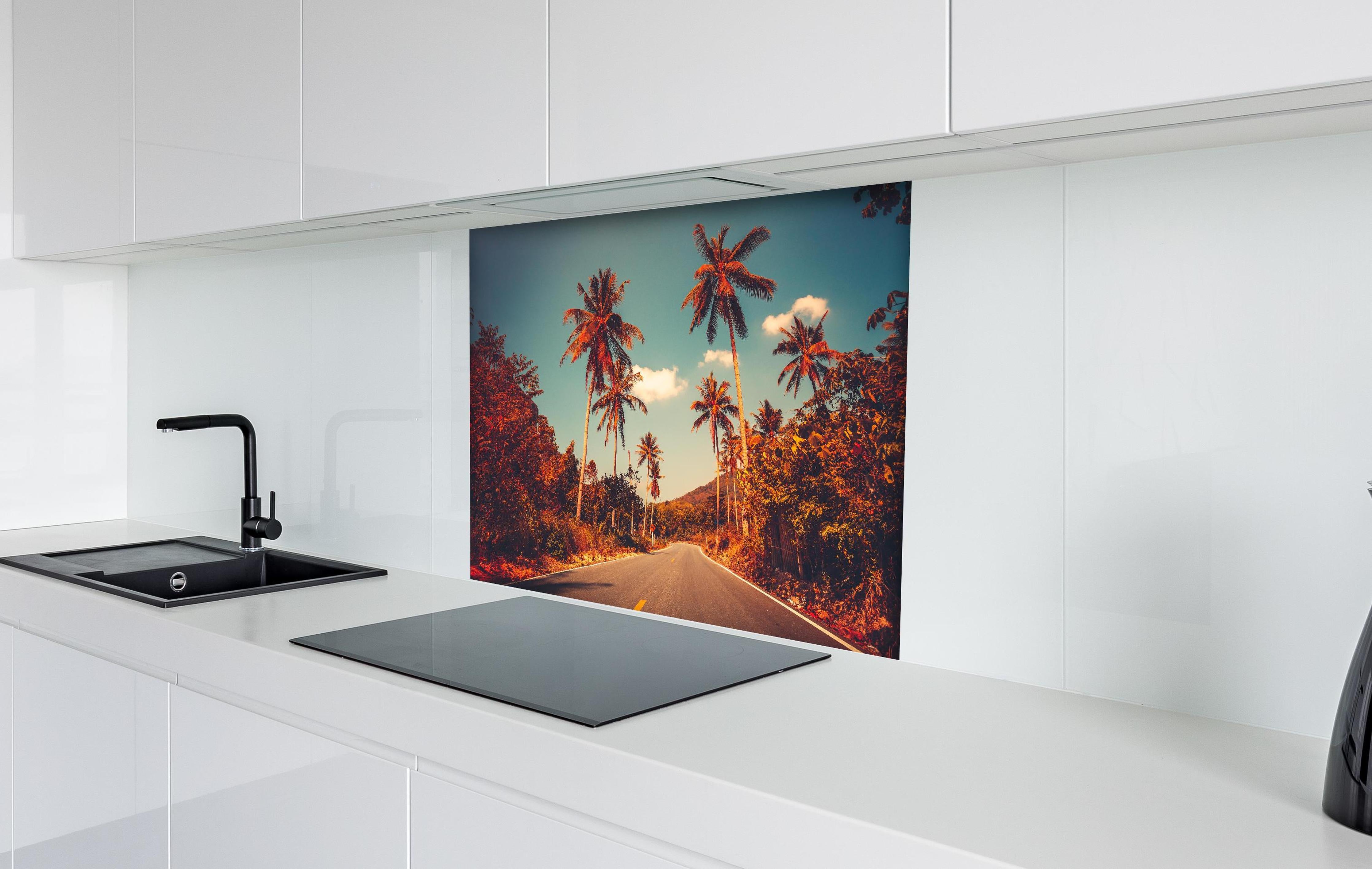 Spritzschutz - Exotischer Sonnenuntergang Palmenlandschaft Bild hinter einem Cerankochfeld zwischen Holz-Kochutensilien