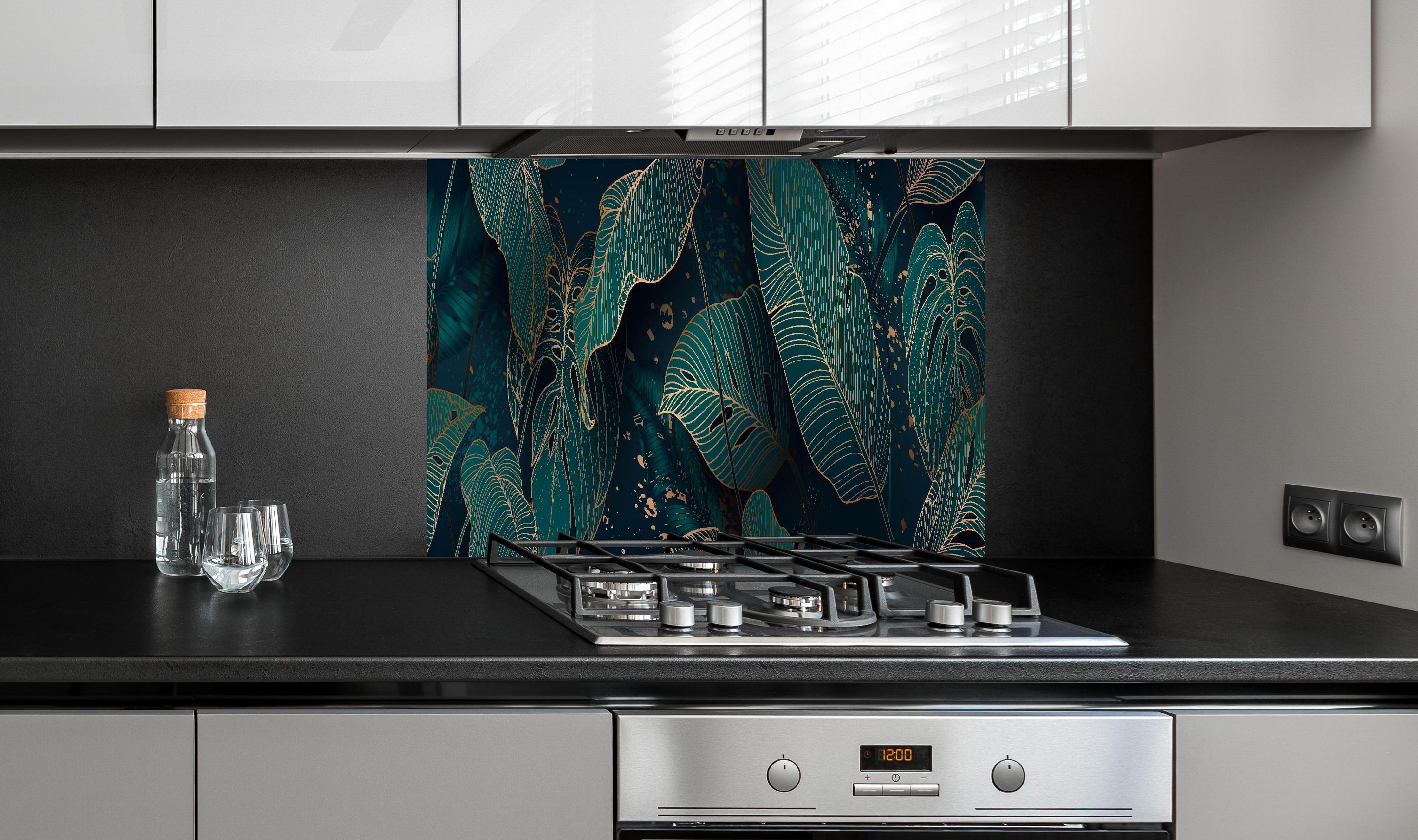 Spritzschutz - Exotisches Blattwerk Design in Dunkelgrün hinter einem Cerankochfeld zwischen Holz-Kochutensilien